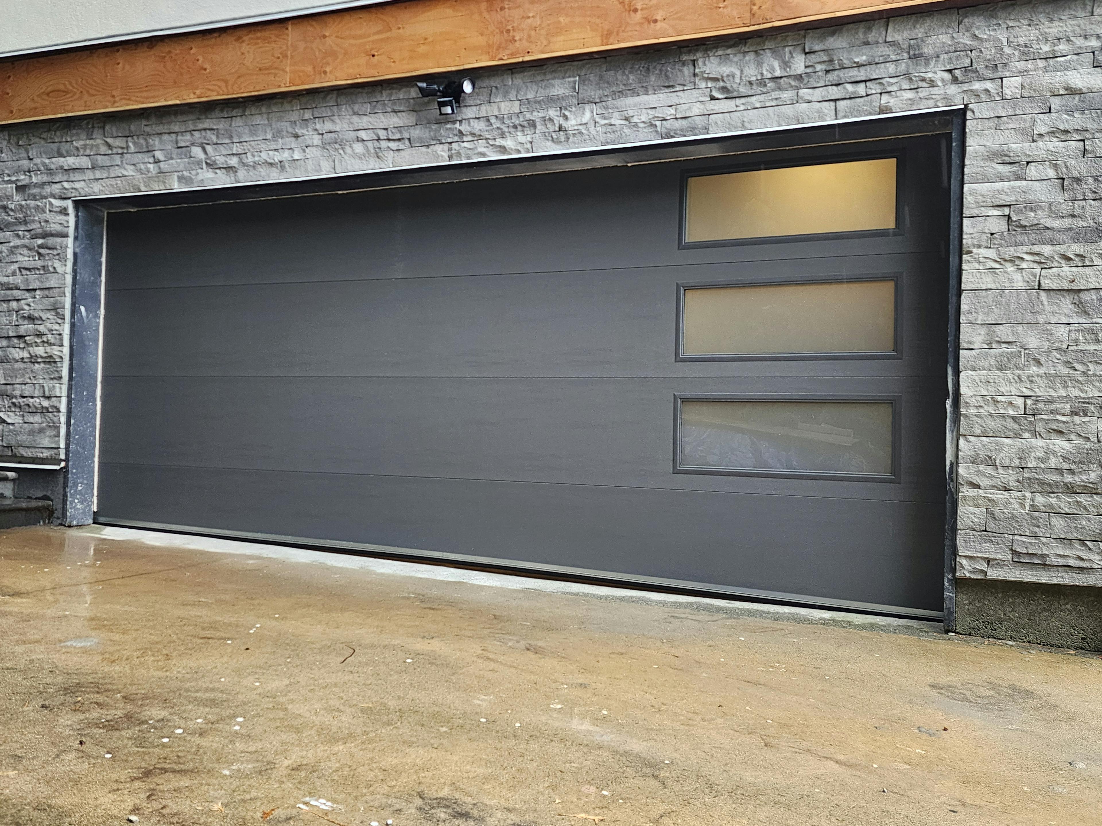 a custom garage door installation in West Vancouver featuring a 16x6'9" Steel-Craft R16 Flush panel door in Sable Grey