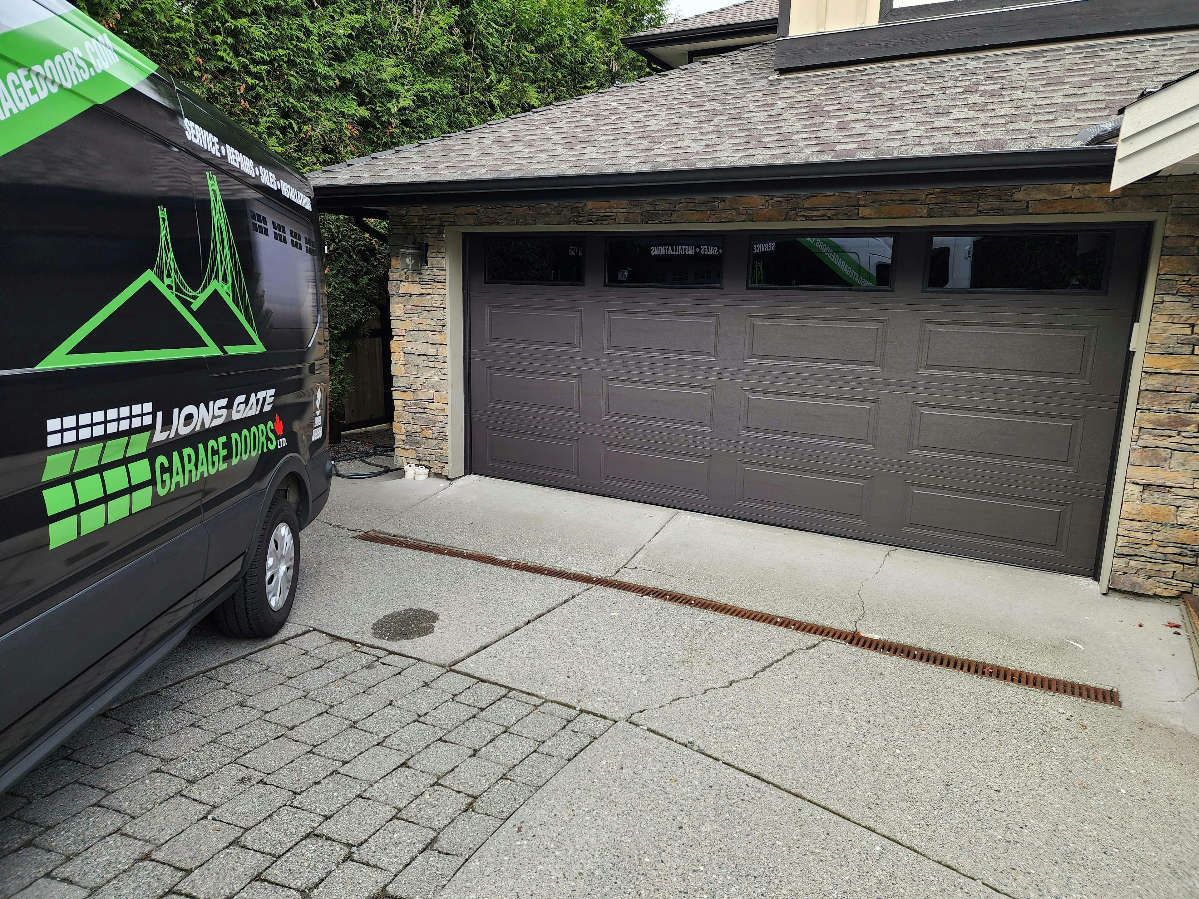 a 16x7 SteelCraft RanchCraft Ridgeline door in Charcoal color with double pane dark tint glass in the top section