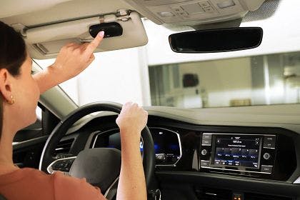 woman pusing the LiftMaster 3-Button Remote while on car visor