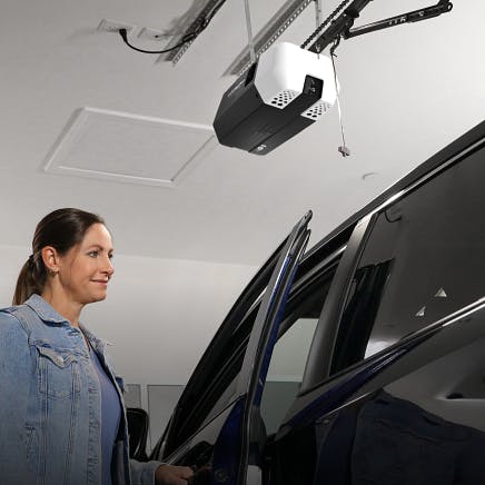 a woman getting into a car under the LiftMaster Quiet DC Chain Drive Opener with Camera