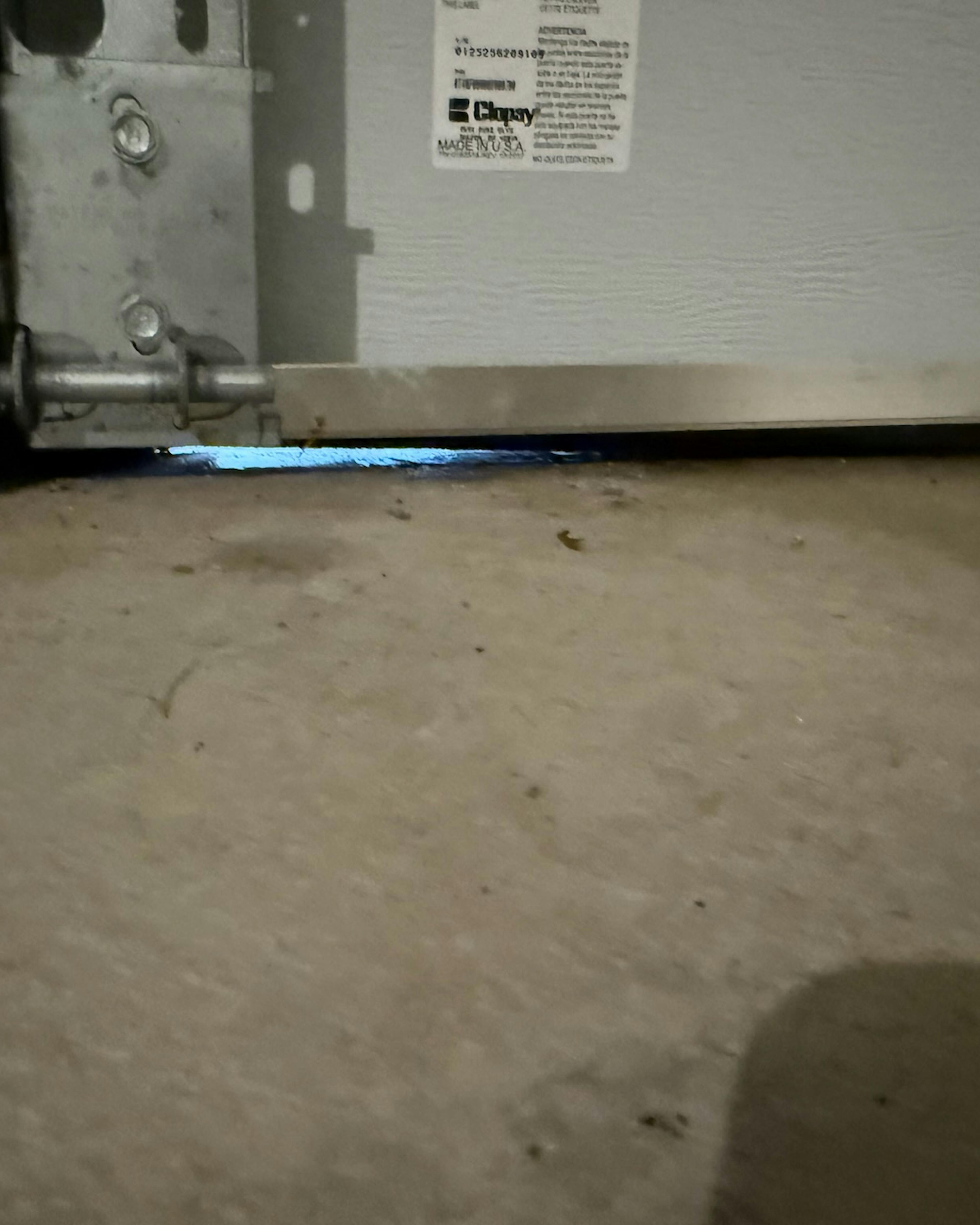 close-up of a garage door with daylight coming in from the bottom right corner providing space for pests to enter close-up of a garage door with daylight coming in from the bottom right corner providing space for pests to enter