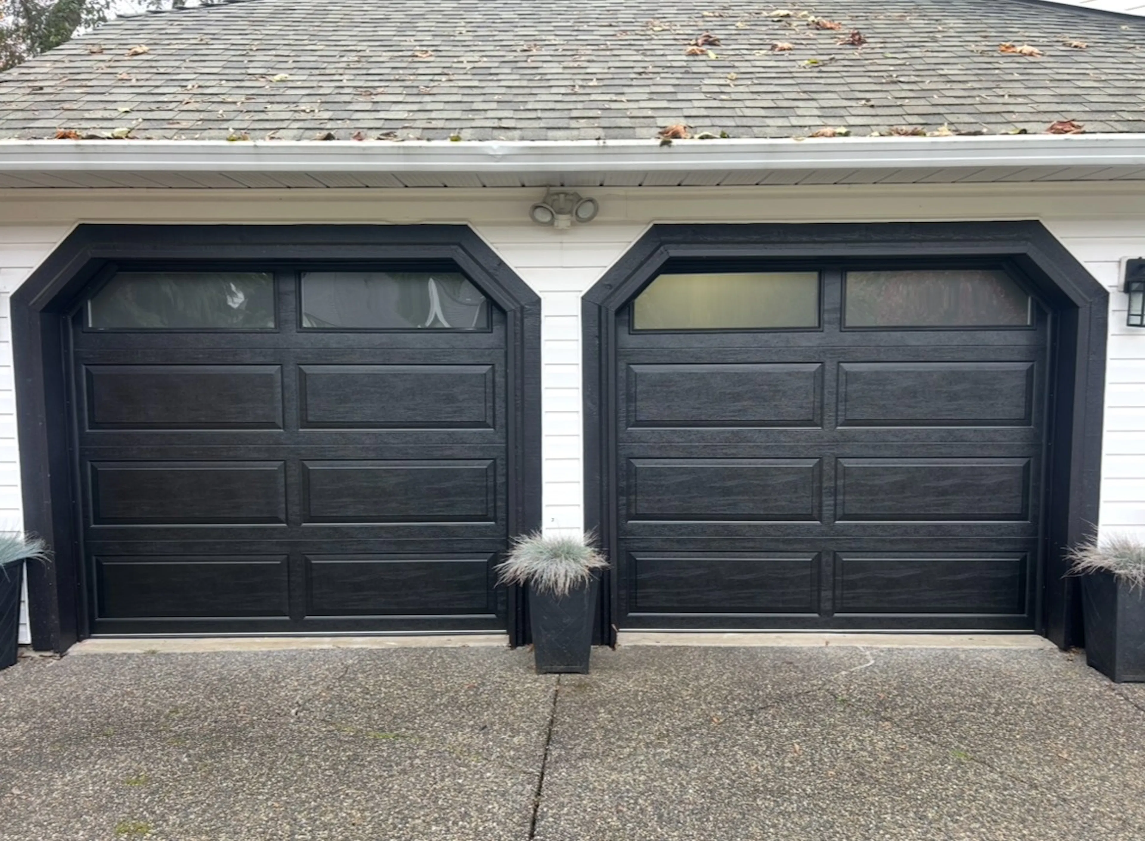 two 8x7 Northland R12 doors with a black wood grain finish and a classic Raised Ranch Panel design