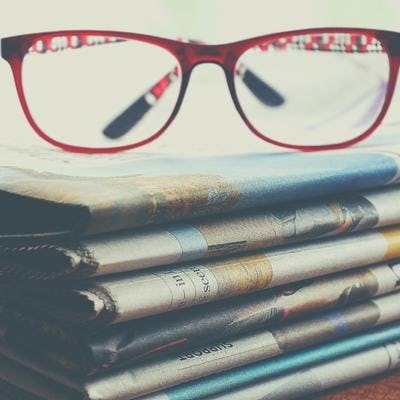 Glasses on a stack of newspapers
