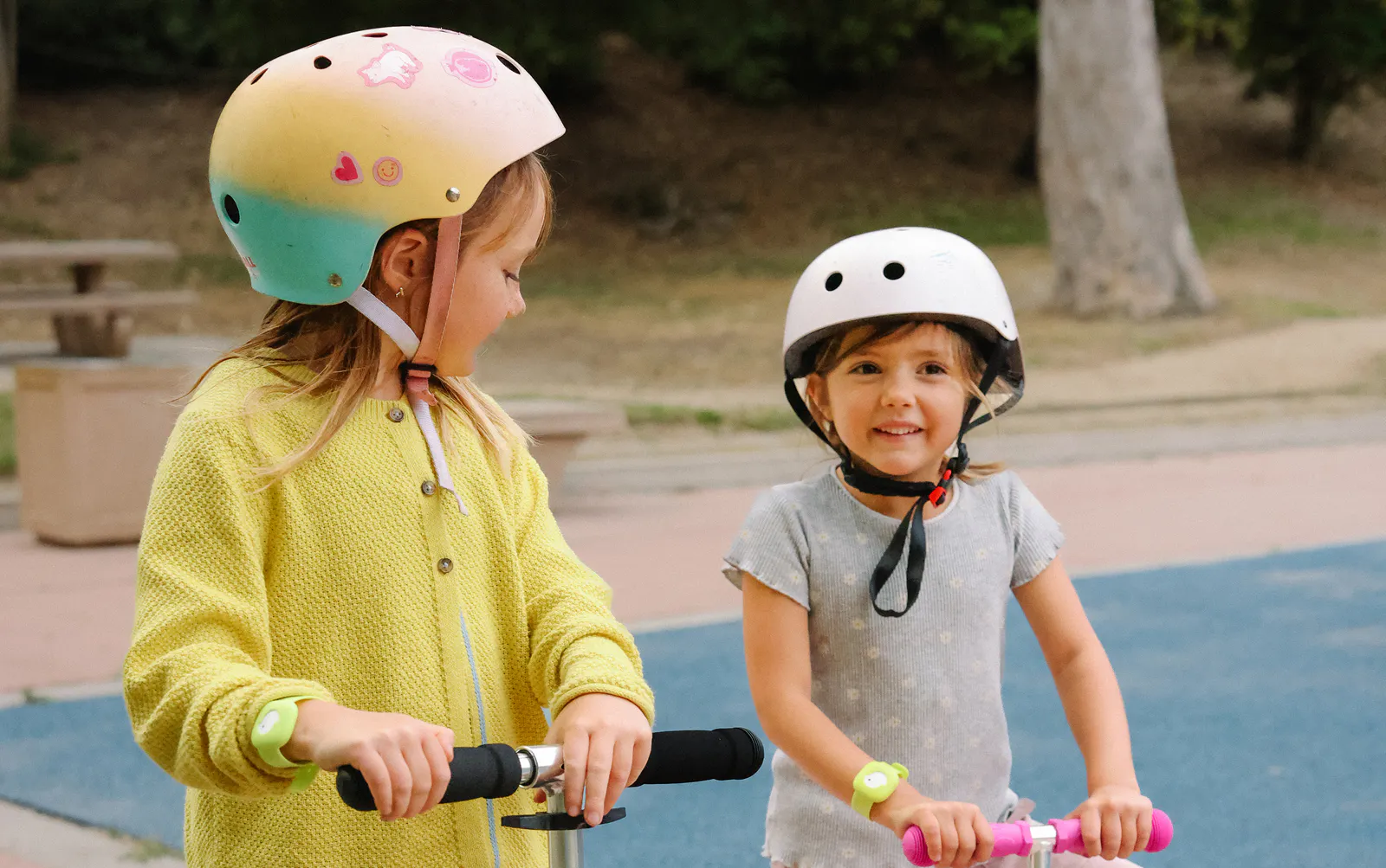 Girls wearing Littlebird tracker riding scooters
