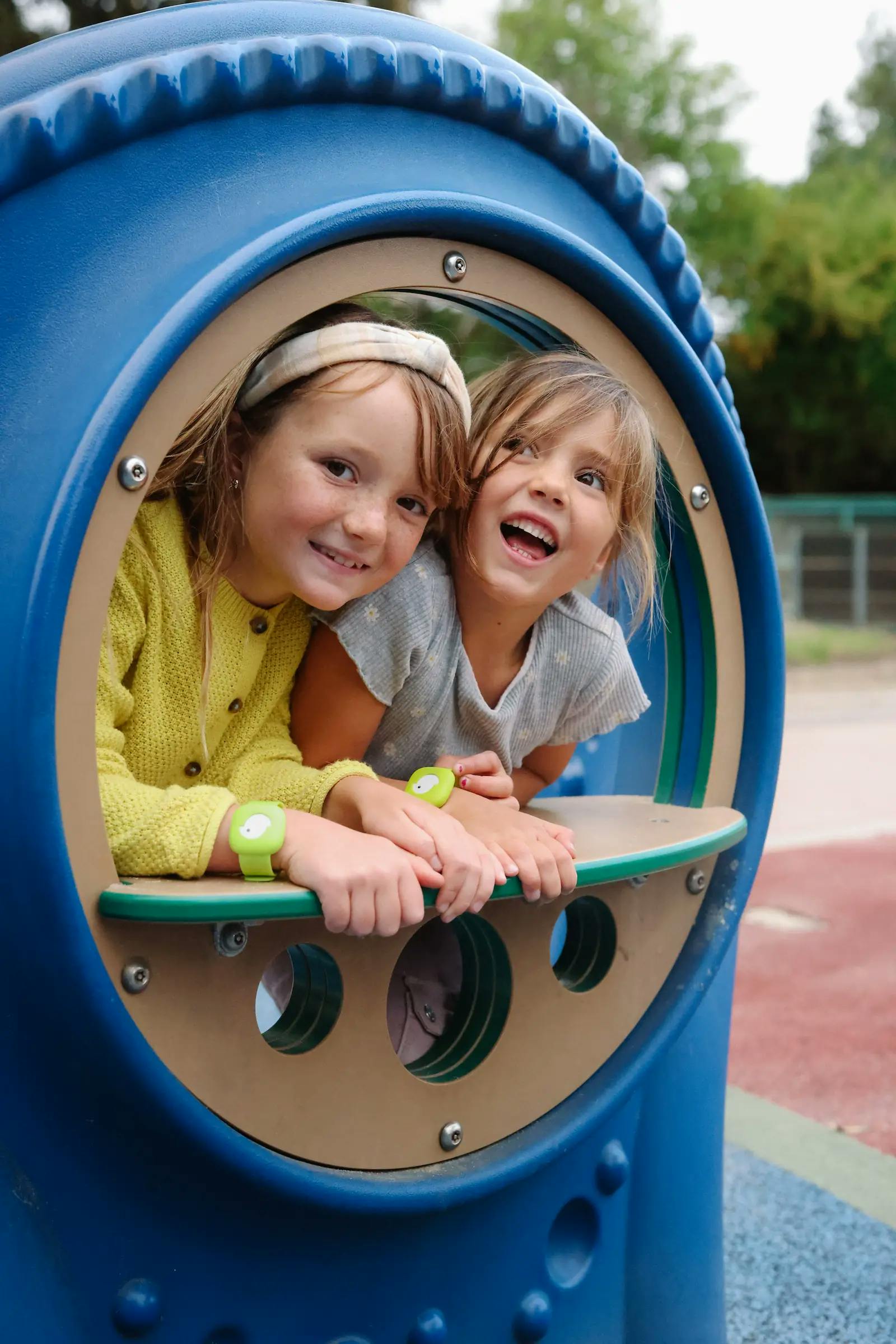 Girls peeking out of a window at a playground