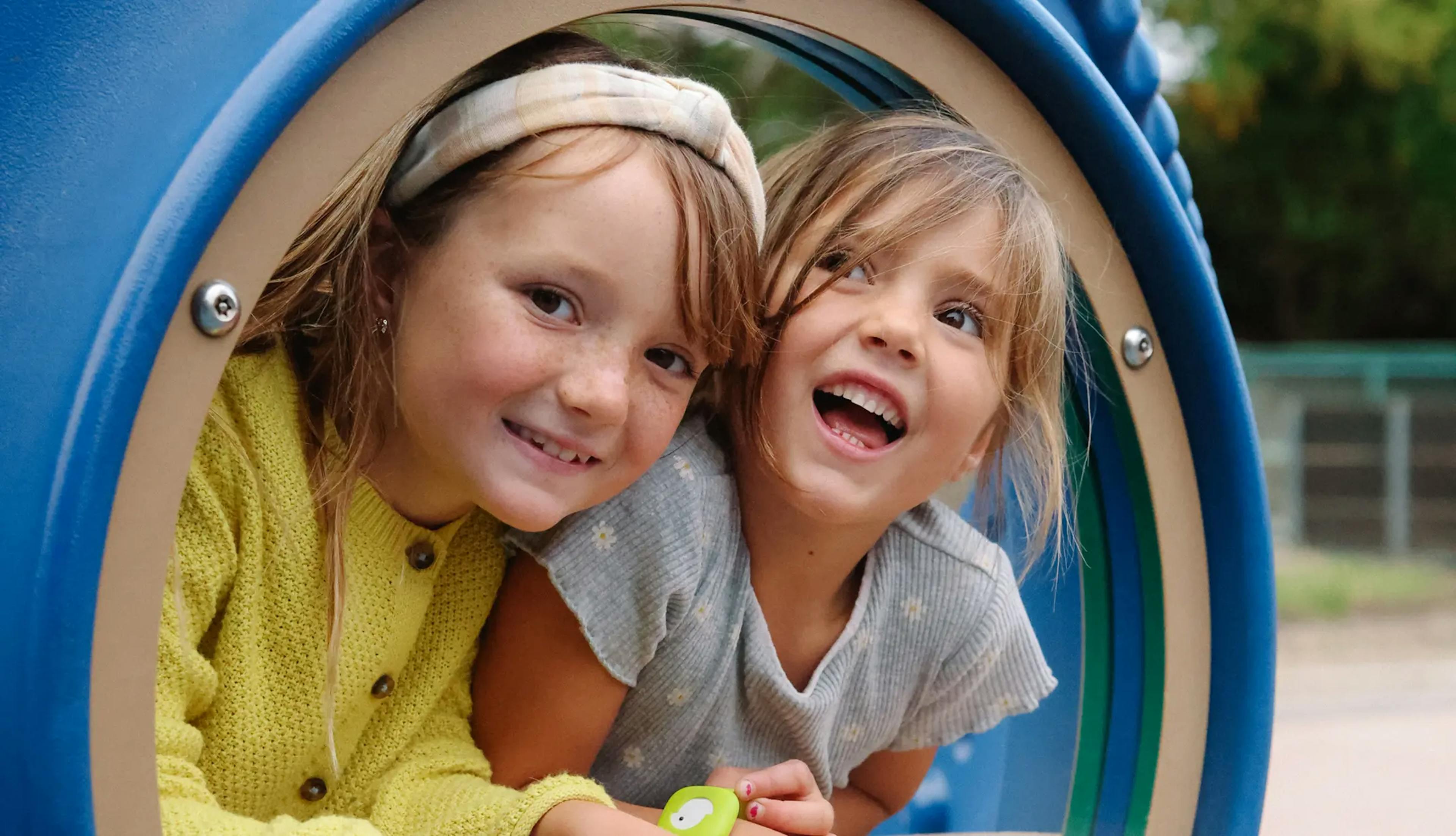 Girls peeking out of a window at a playground