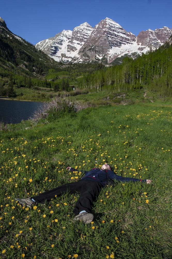 Me laying in some grass with the Maroon Bells in the background