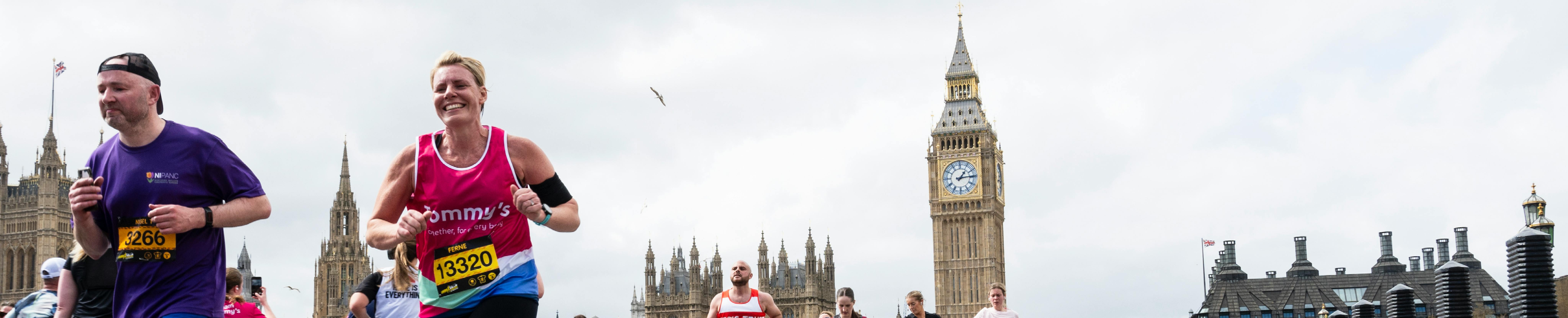 Man running the LLHM in pink Tommy's top, running past big ben.