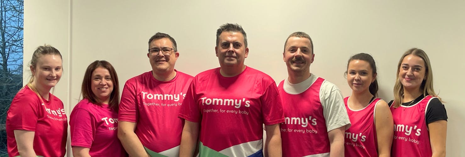 A group of runners smiling in Tommy's and London Landmarks branded tops