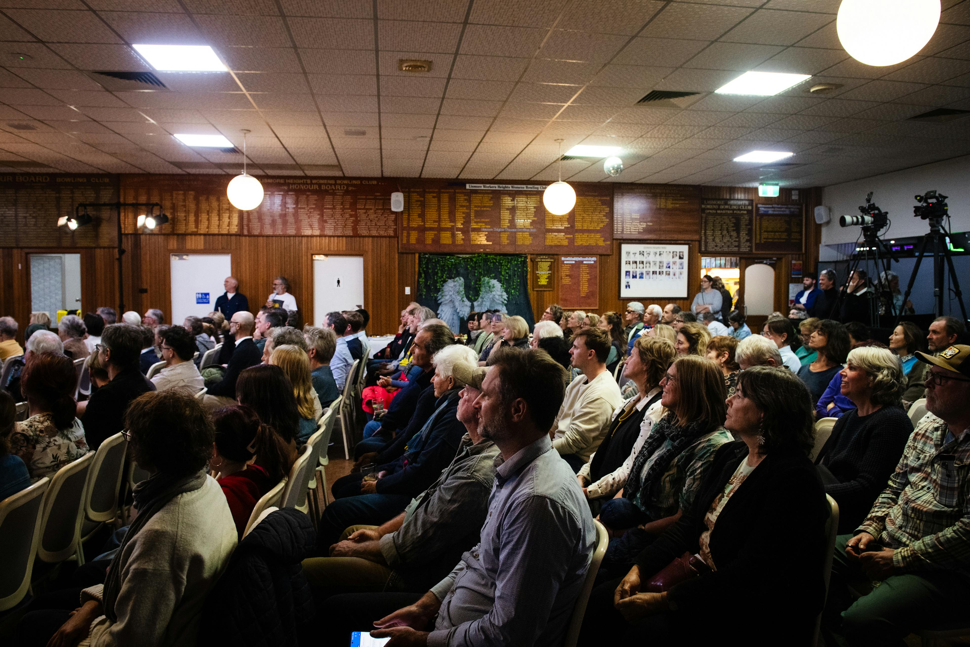 People seated, attending a community meeting.