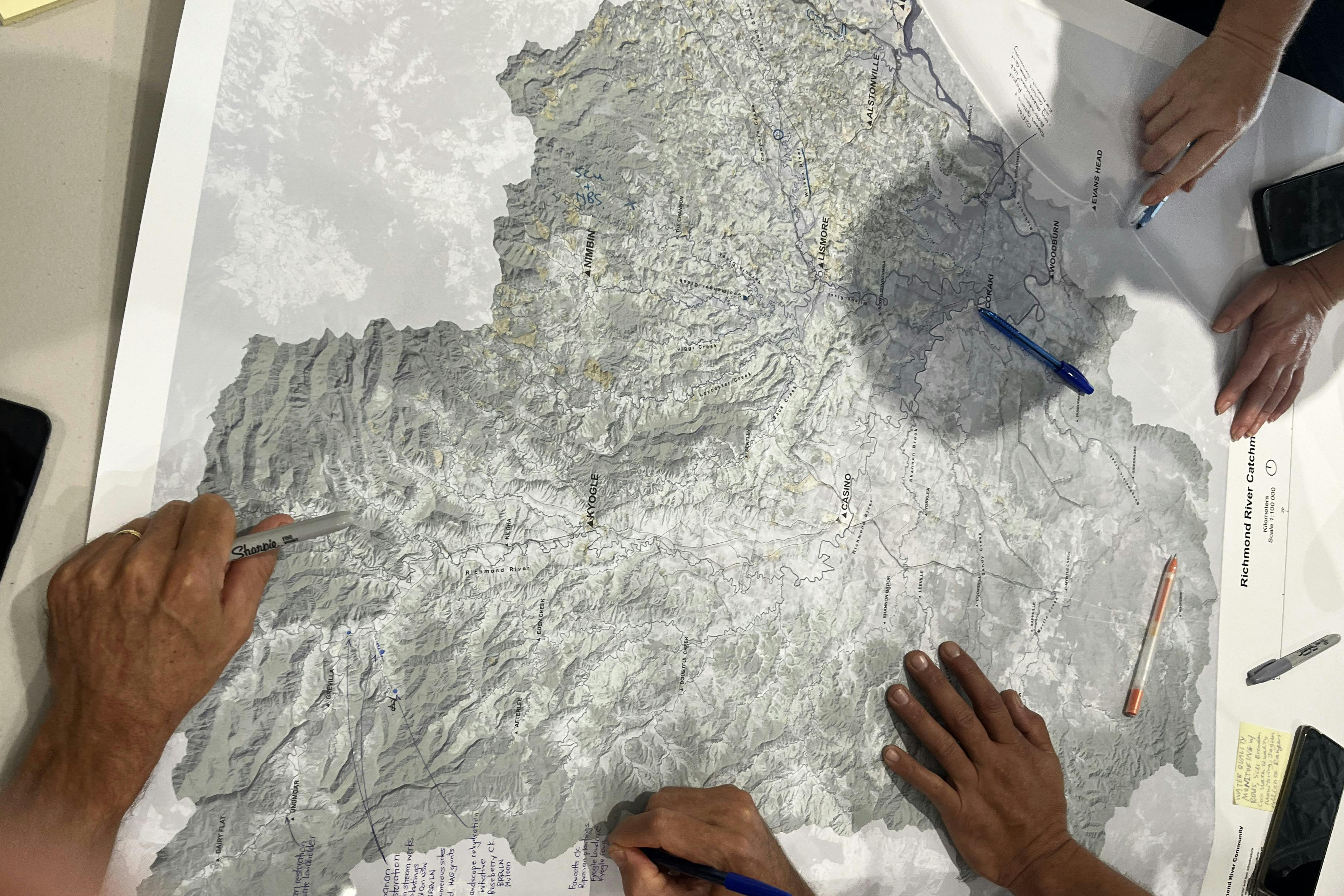 Workshop participants marking up projects and comments on a map of the Richmond River catchment.