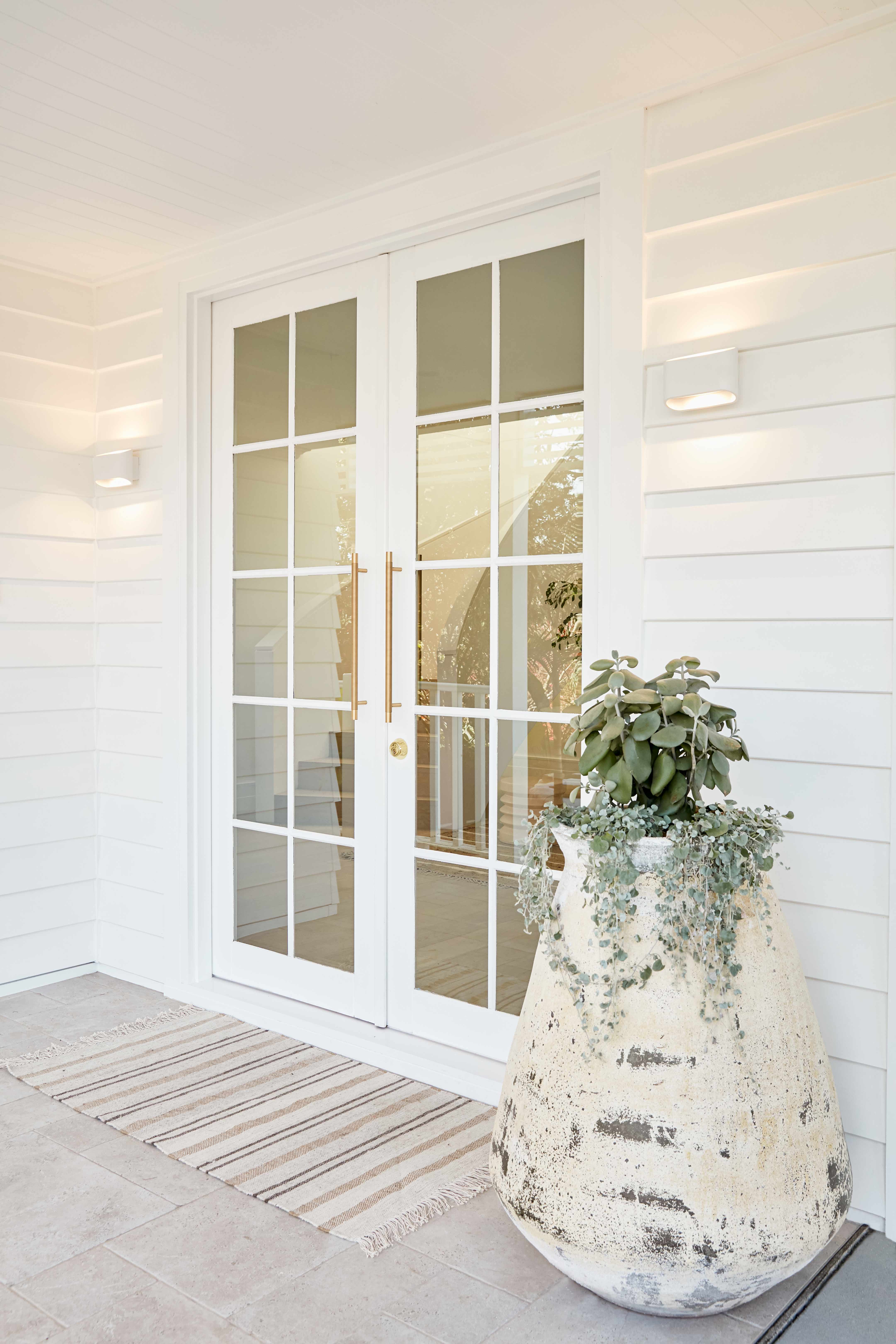 Lo and co gold handles on a white front door