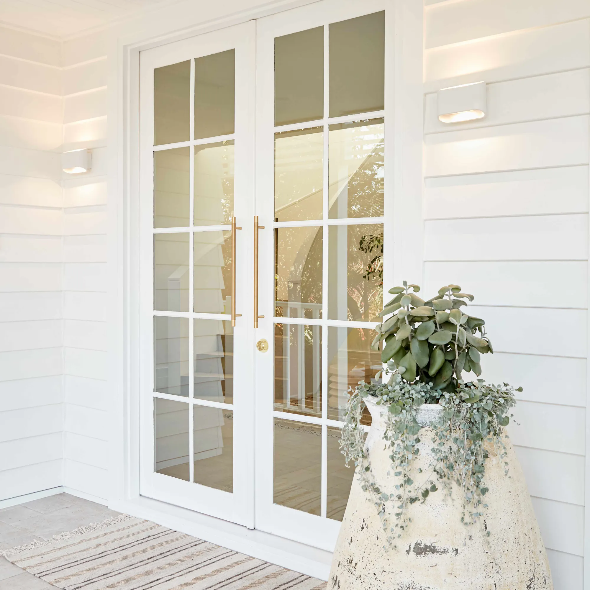 Lo and co gold handles on a white front door