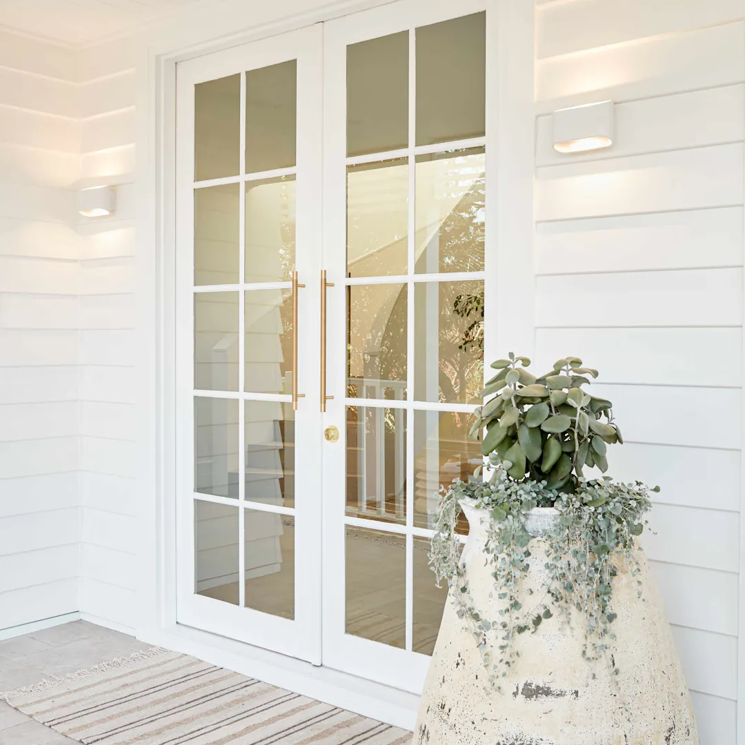 Lo and co gold handles on a white front door