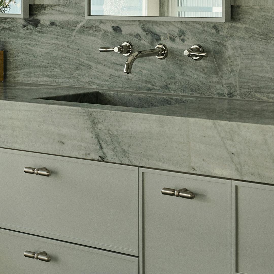 Lo and co cabinet knobs in a green cool toned bathroom