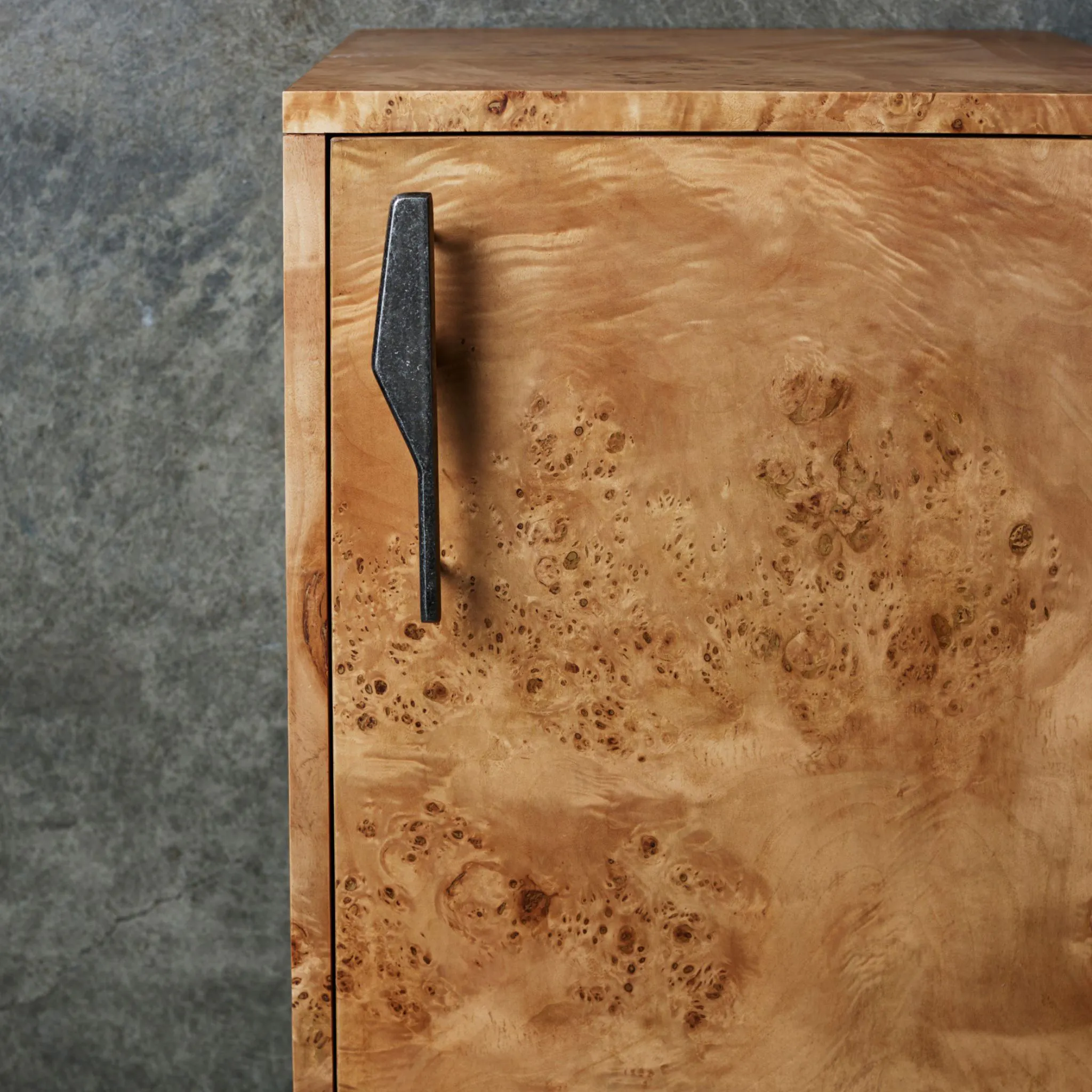 Tumbled nickel handle on a wooden cabinet door