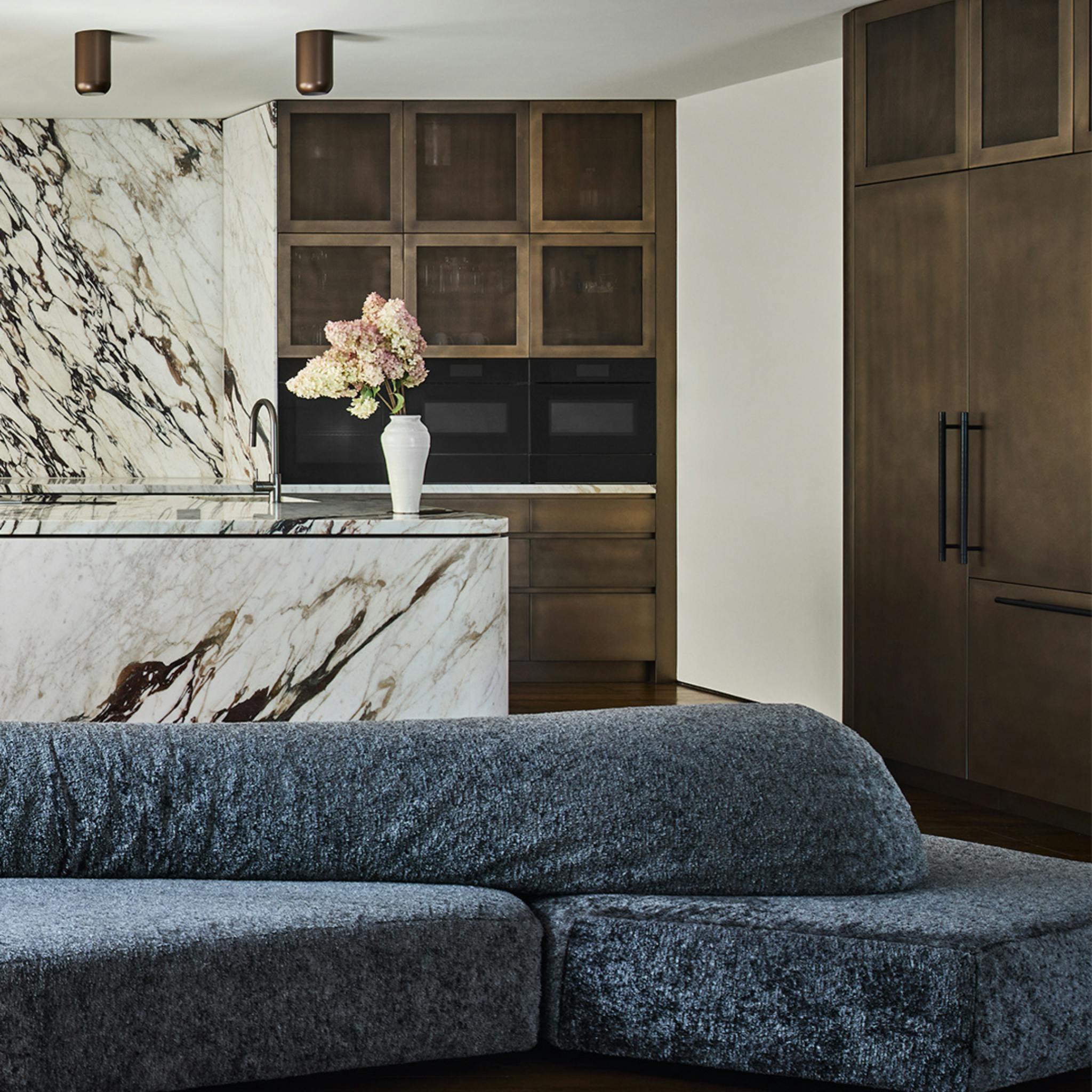 Kitchen with black handles and a blue velvet couch