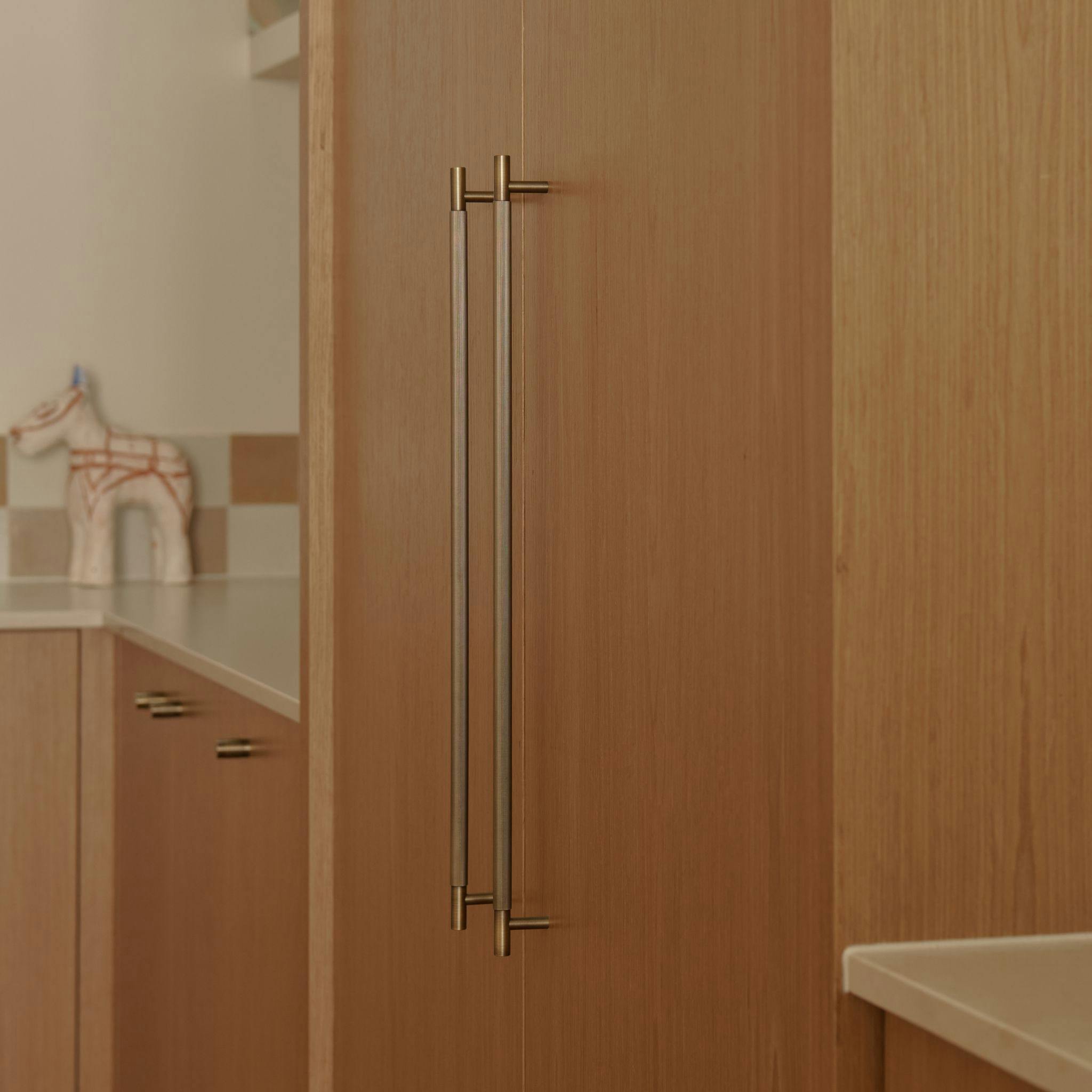 Kitchen with two brass appliance pull handles by Lo and Co Interiors