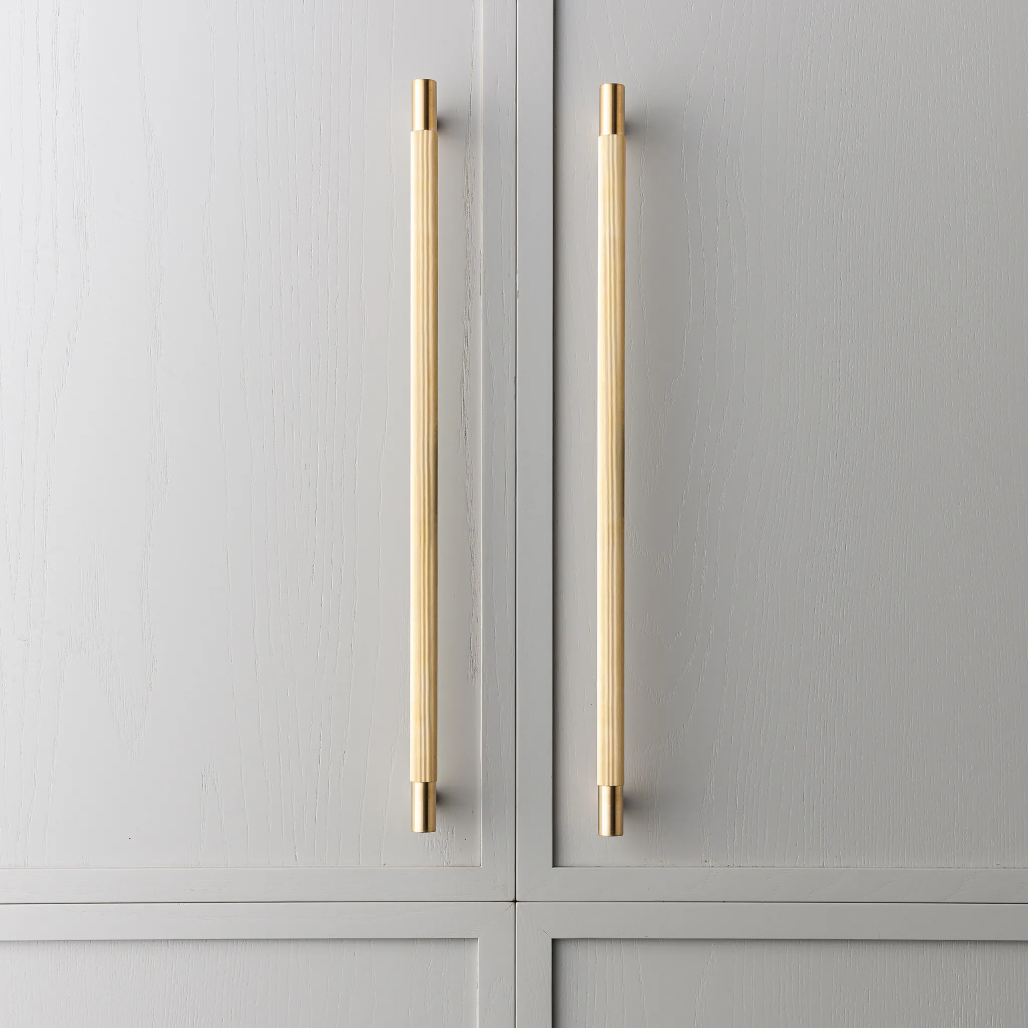 Grey cabinets with two large live brass appliance handles