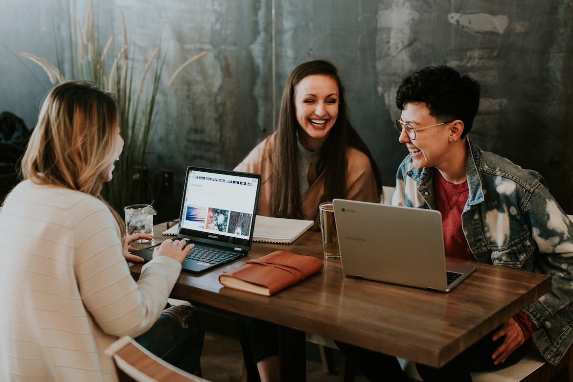 A group of employees happily discussing their business trip plans before applying for a business travel visa.