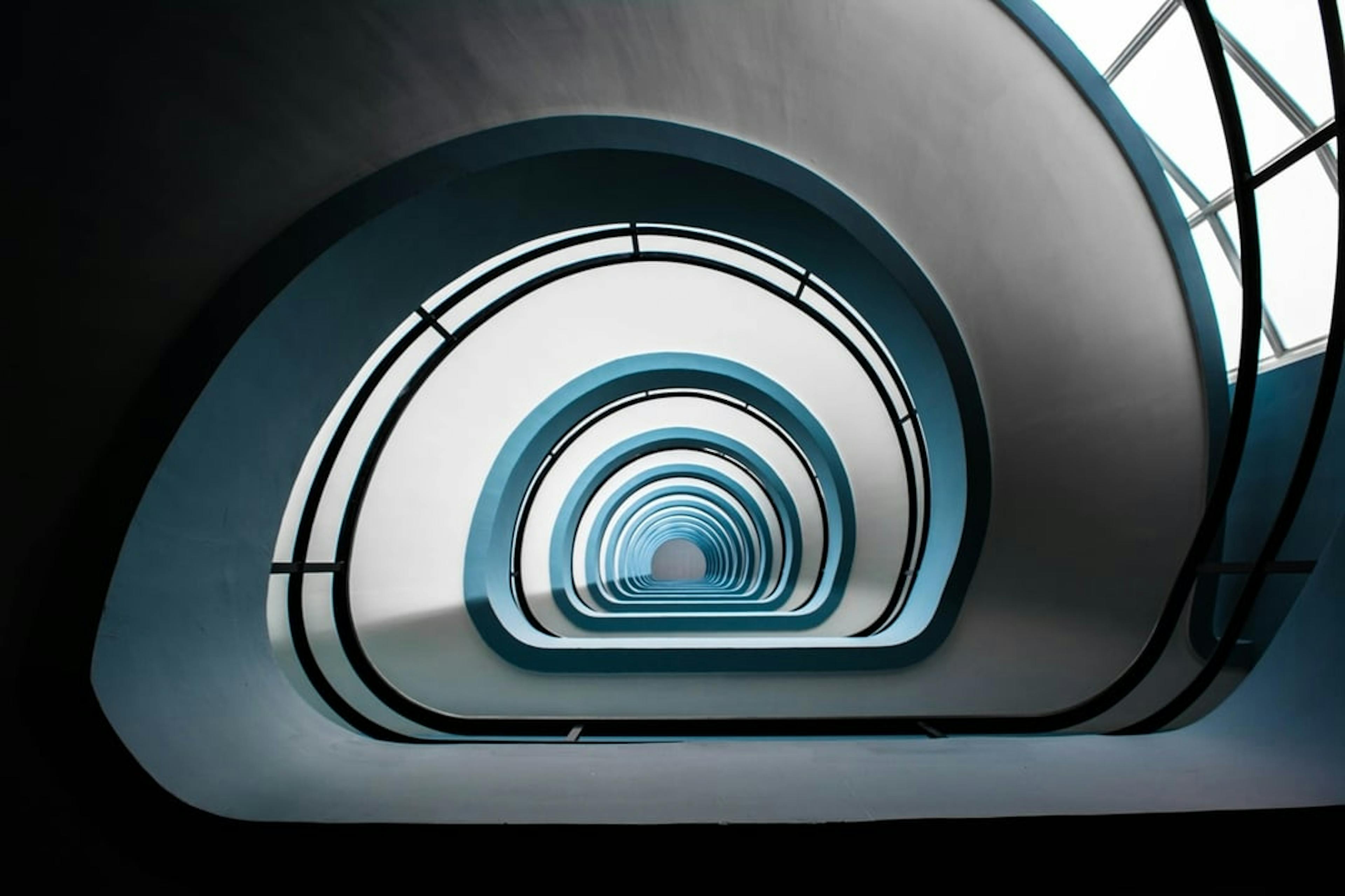looking up on a spiraled stairway of a tall building