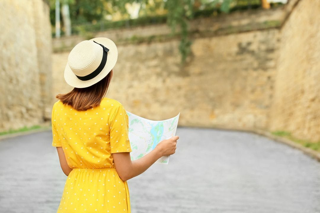 an expat explores a new city while holding a paper map