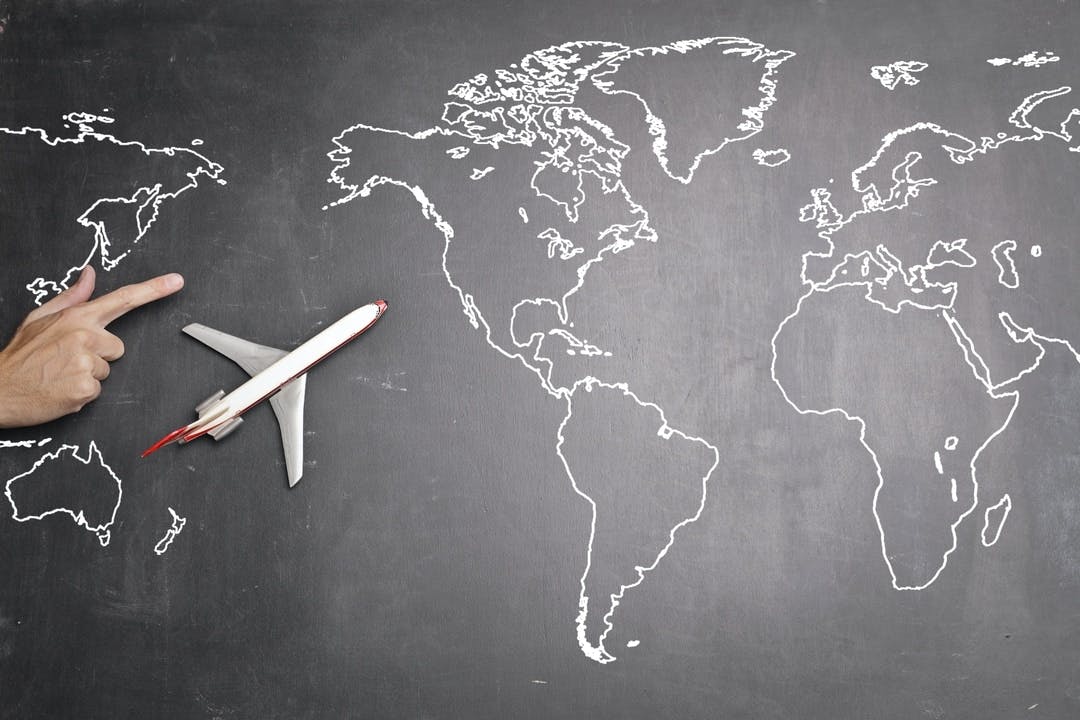 a toy airplane flies over the Atlantic Ocean on it's way to Europe on a chalk map