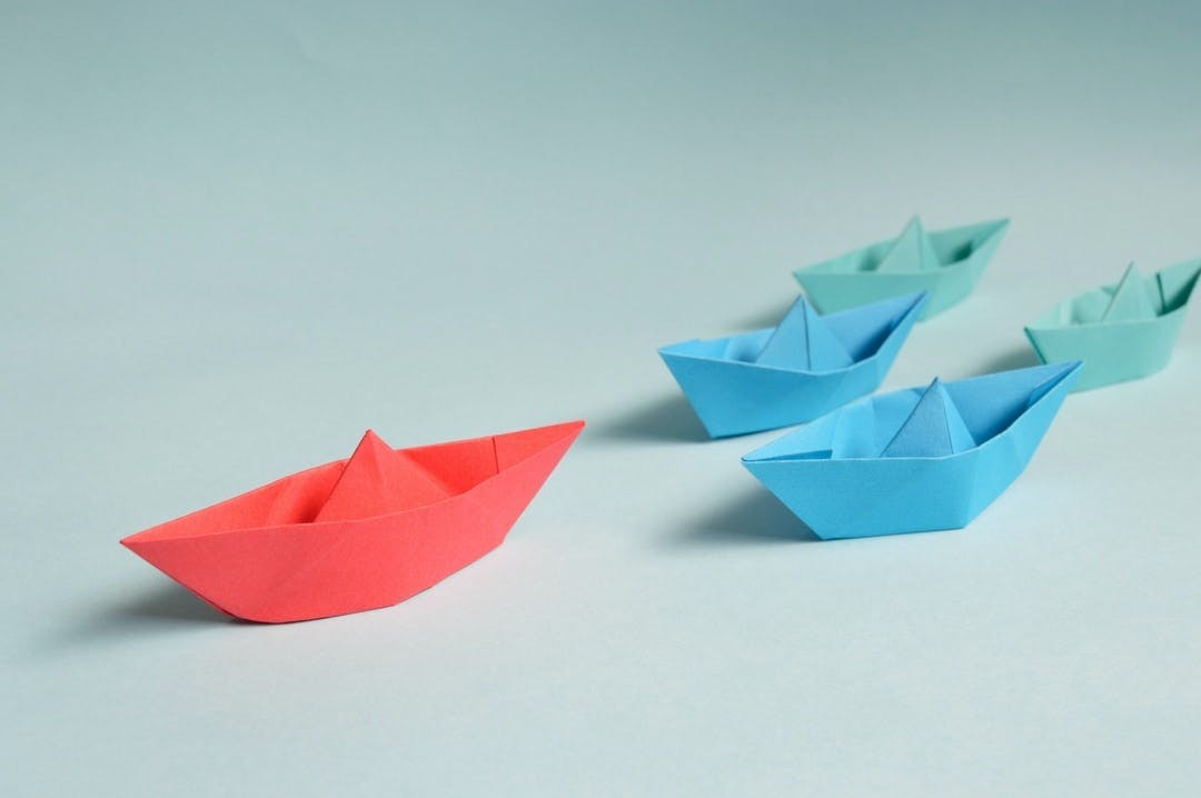origami boats in green, blue and red