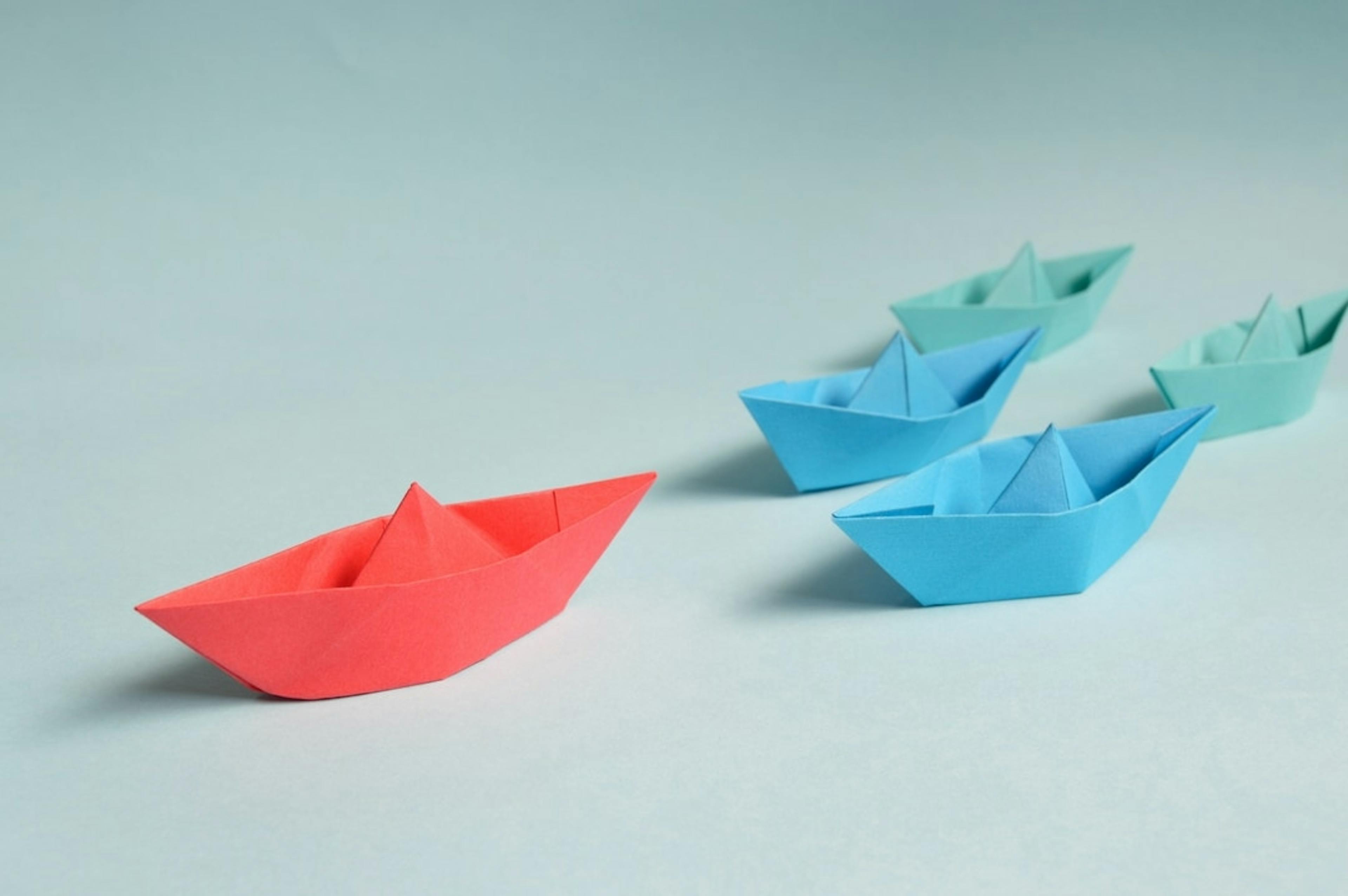origami boats in green, blue and red
