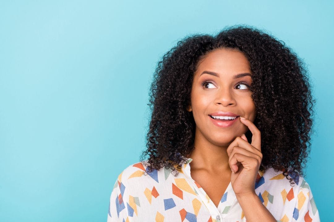 a young, black woman excitedly looks to the left