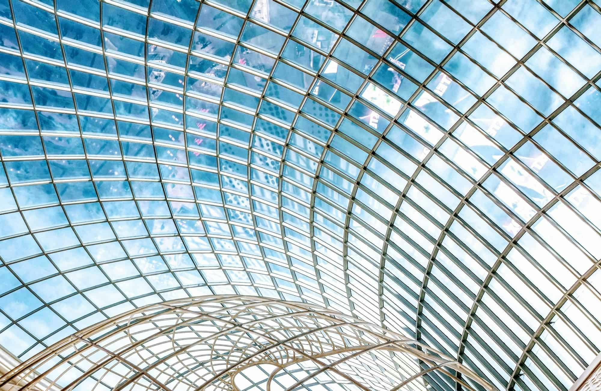 looking out of a glass building onto a blue sky