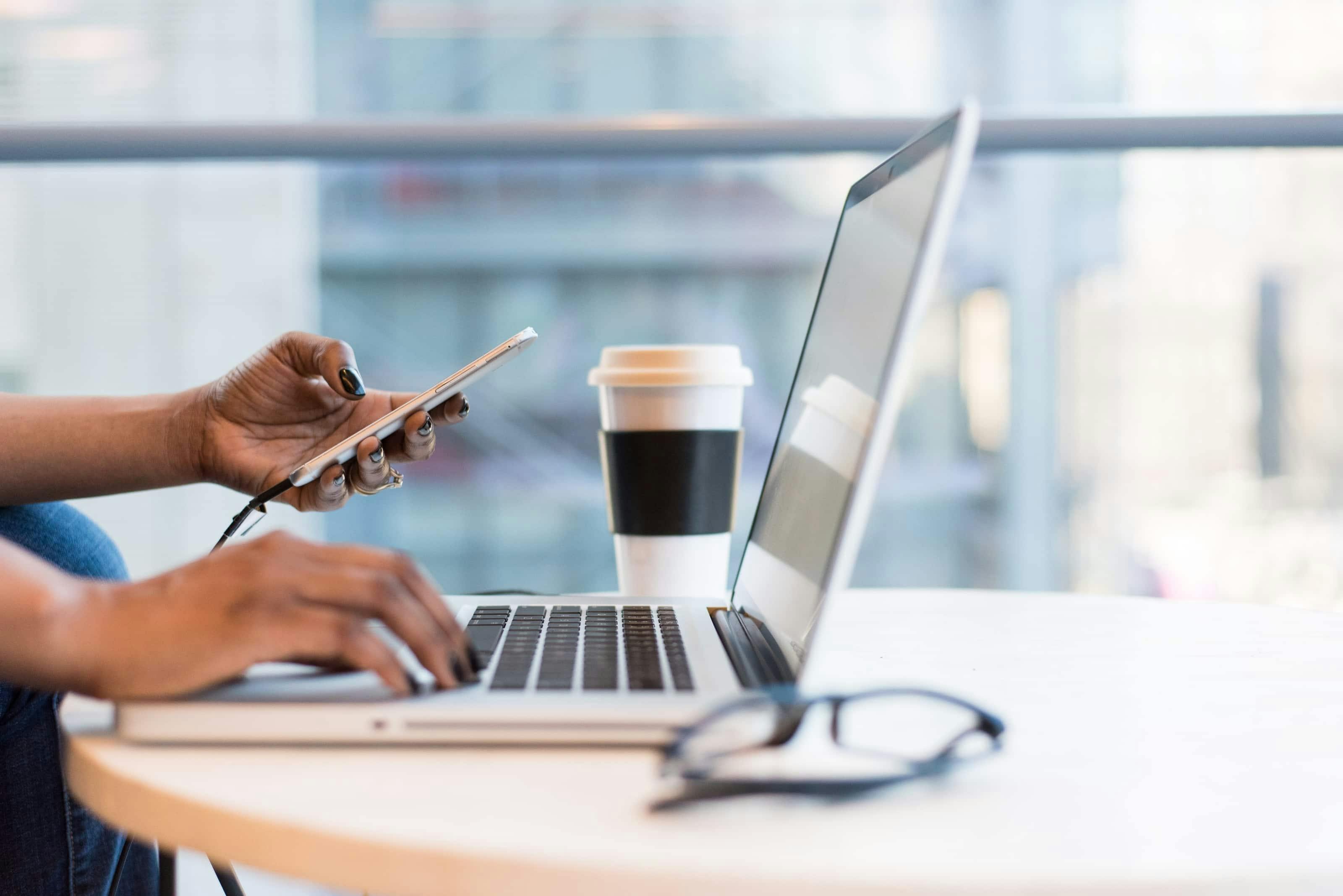 work from home vs work from anywhere - employee works from laptop at cofee shop