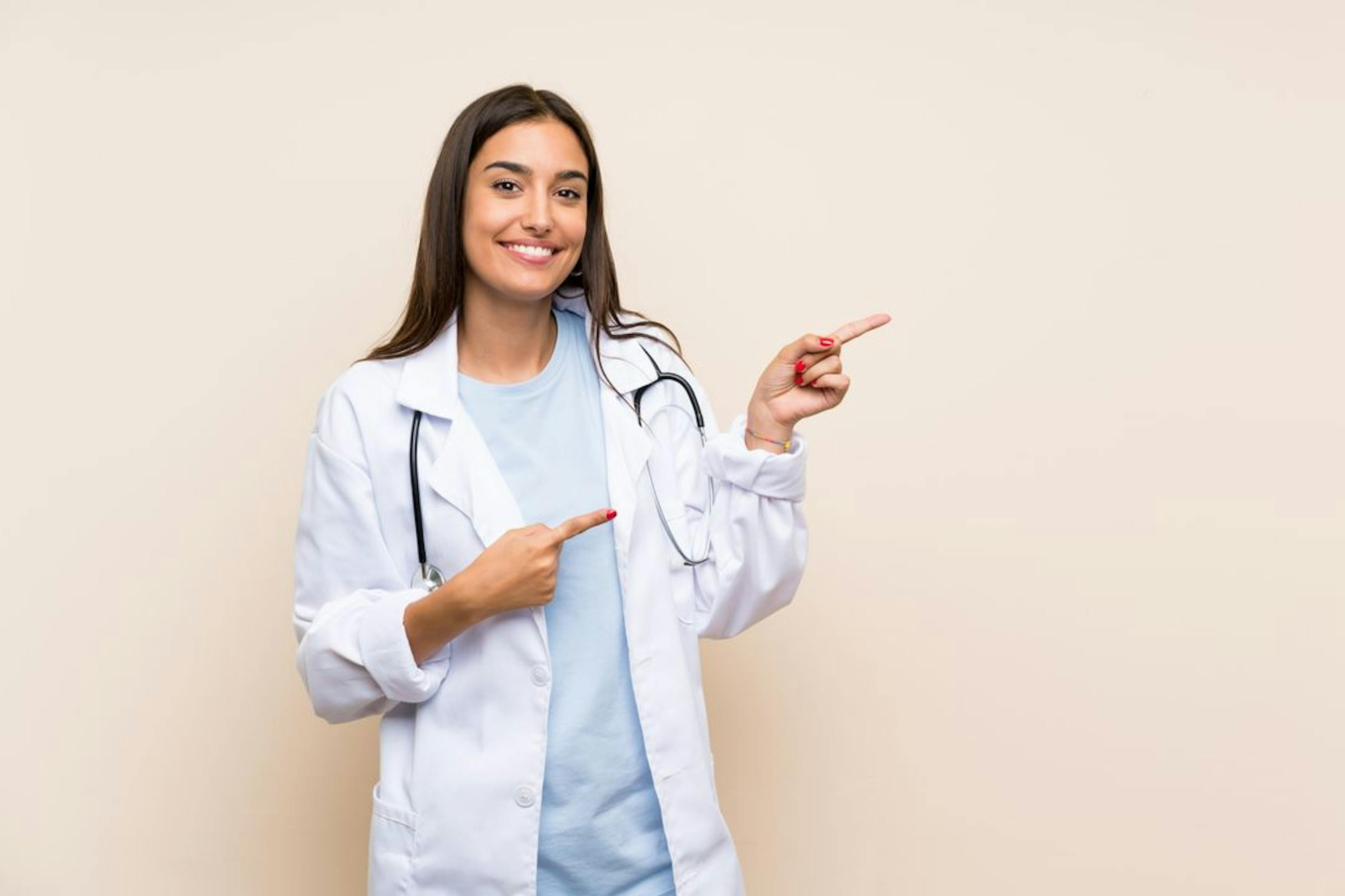 healthcare worker in lab coat pointing fingers to the right