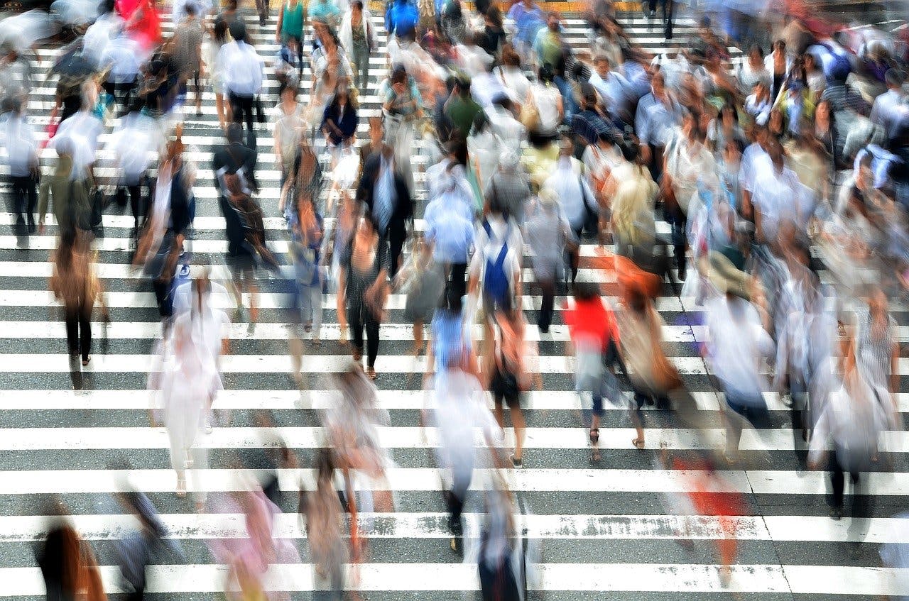 blurred pedestrians crossing a busy intersection