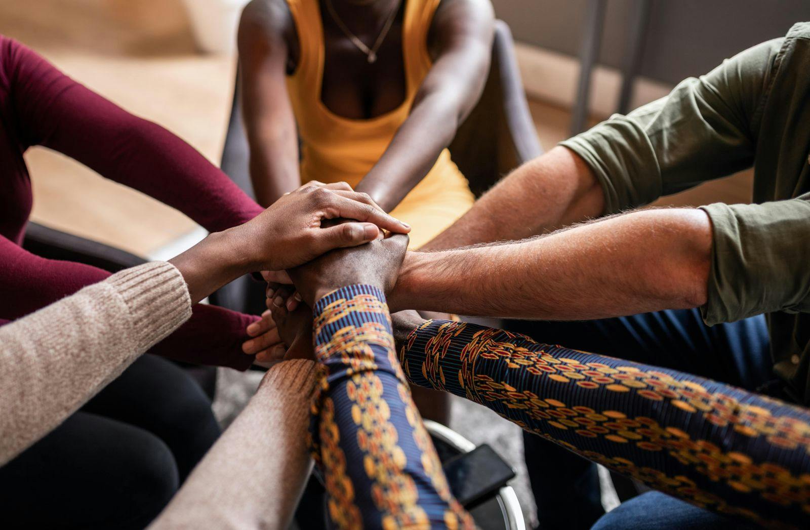 hands of all colors in a "go team" pile at the end of a strategy meeting on how to hire more refugees