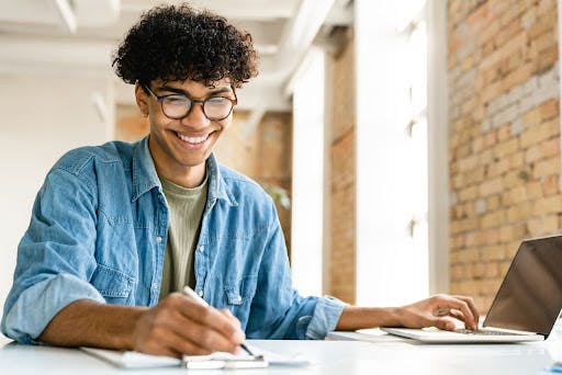 a young man works on recruiting strategy from his laptop