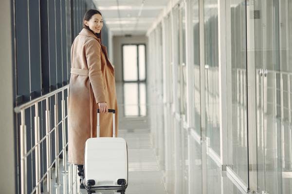 talent mobility is on the rise again as an Asian woman carries her bag down the jetway