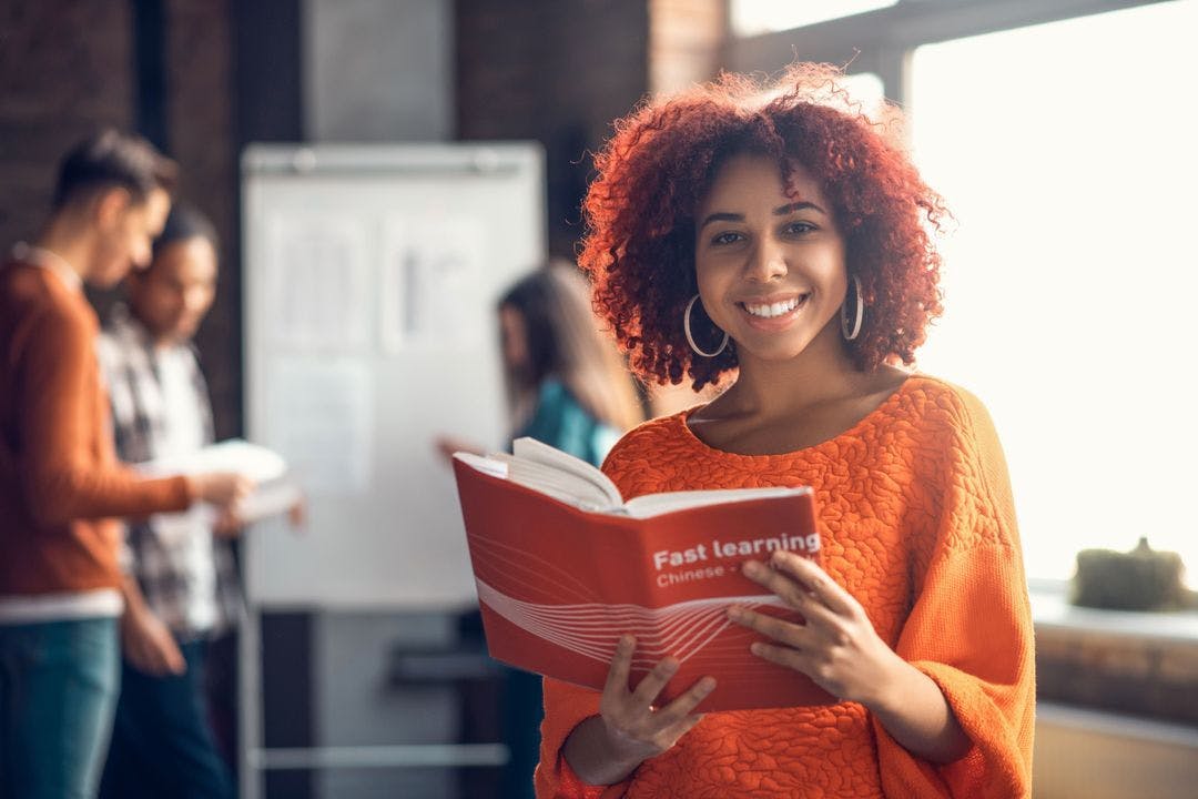 Dark skin woman holding a Chinese language book