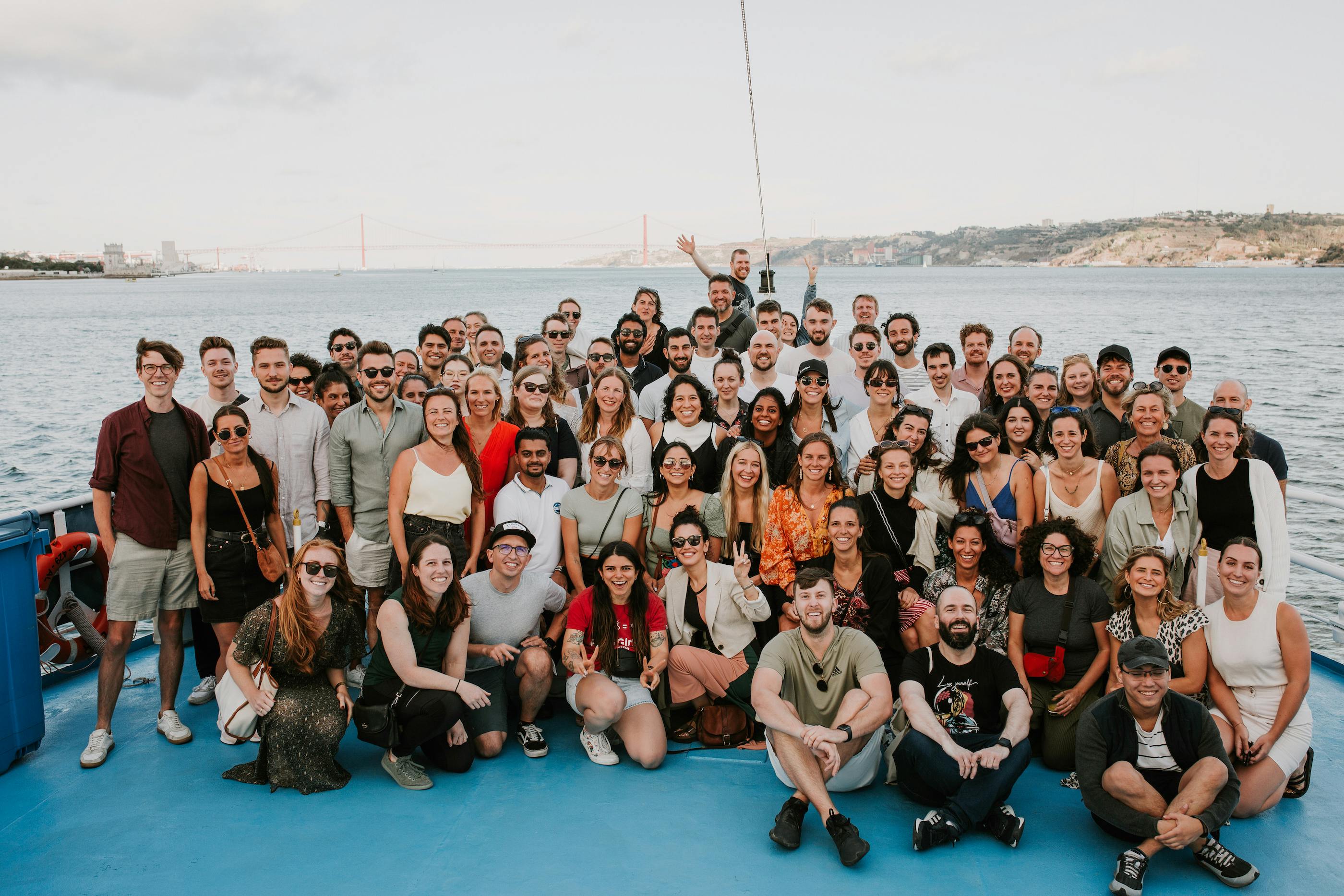 Localyze employees assembled for a group photo on the back of a boat in Lisbon, Portugal