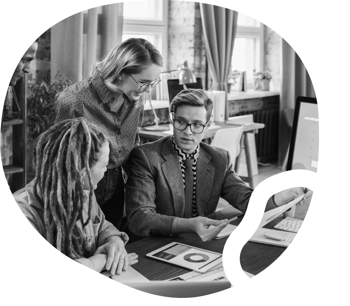 three people in an office around a desk