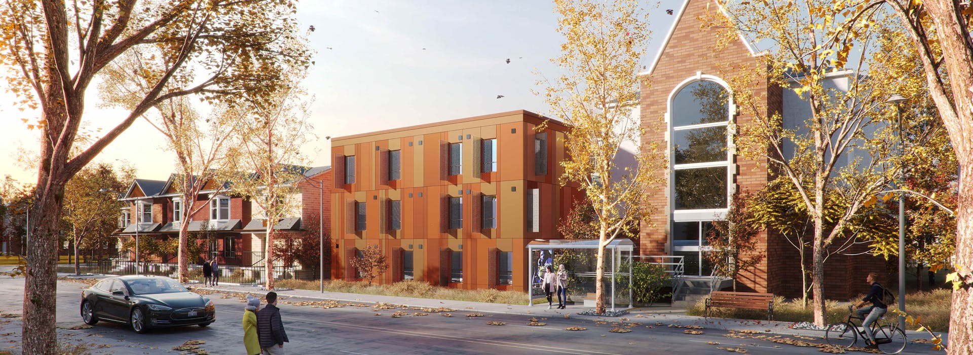 Street view of 1120 Ossington Ave, featuring a modern building with a brick facade next to a historic structure, surrounded by trees with autumn foliage