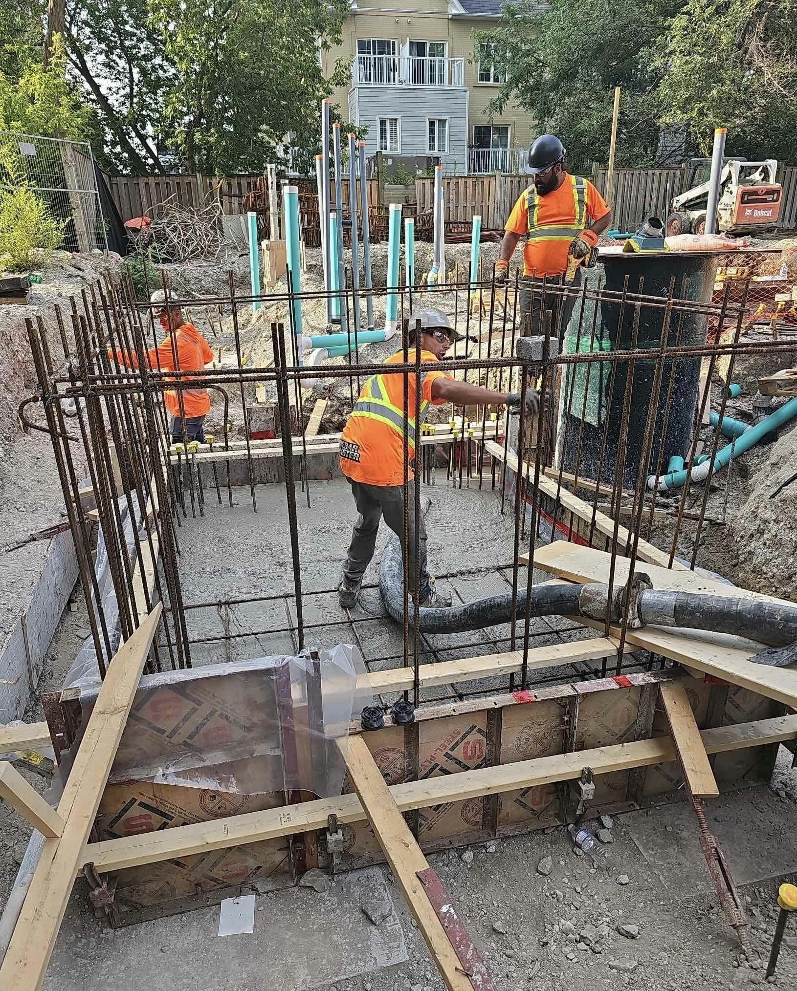 Construction workers at 215 Wellesley St. working on a rebar-reinforced concrete foundation