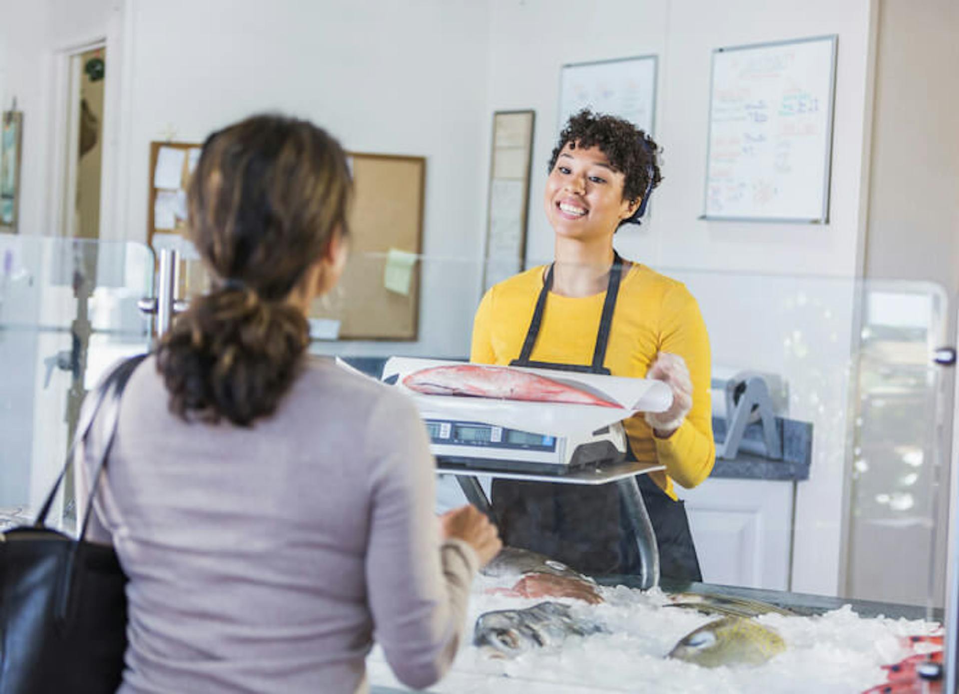 employee handling fish for a customer
