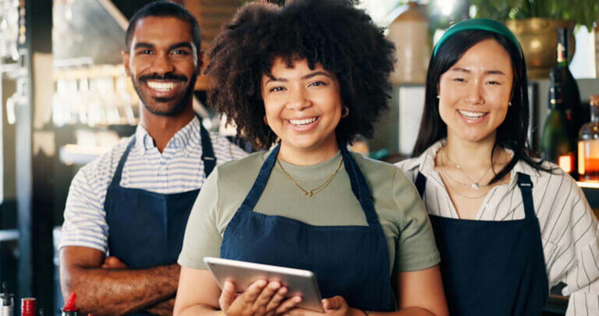 Store employees smiling holding a tablet