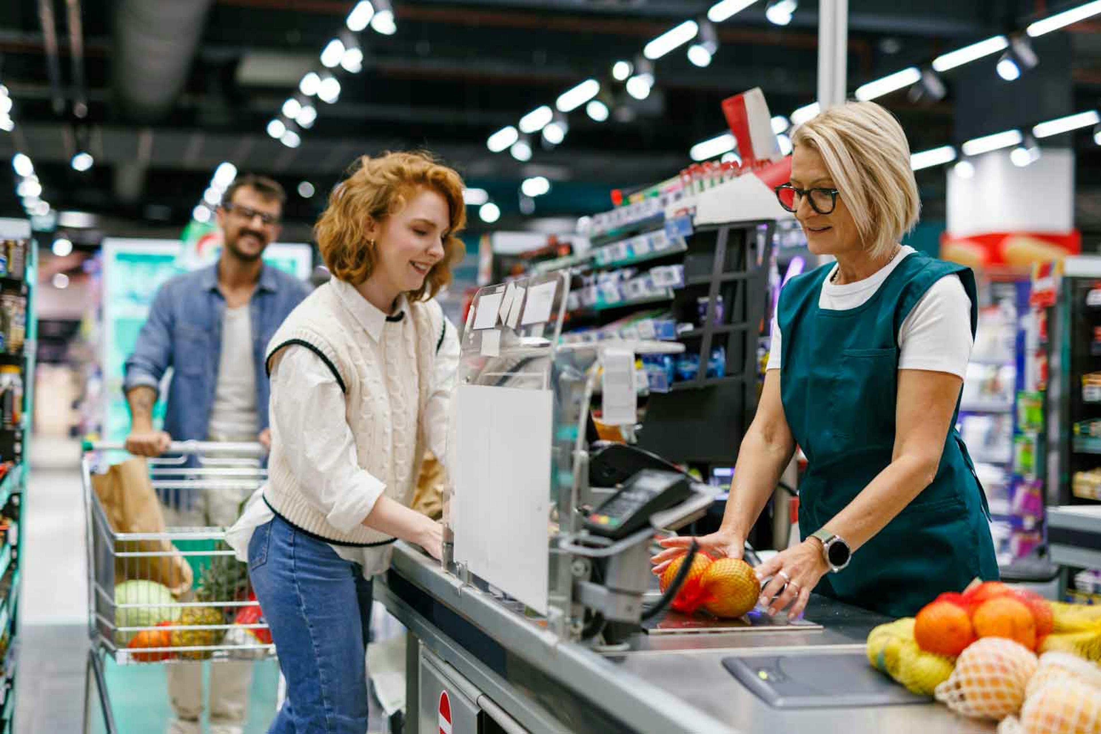 Customer checking out with a retail associate at a supermarket