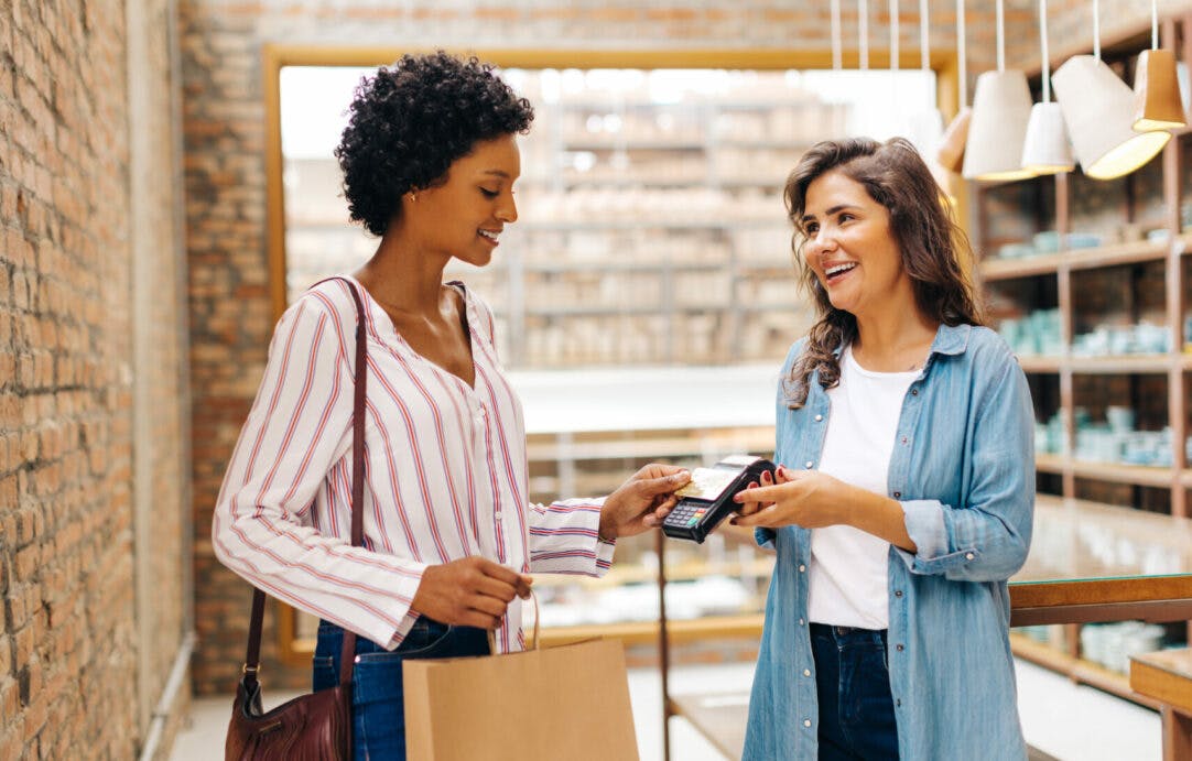A retail shopper quickly purchasing items from smiling employee