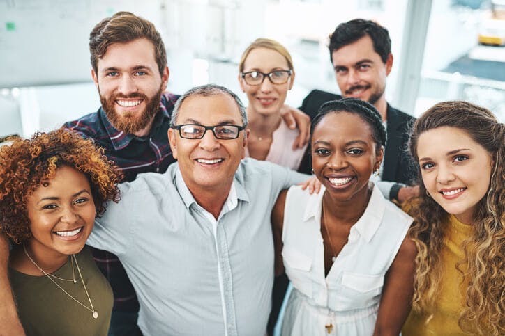 Office workers smiling in a huddle