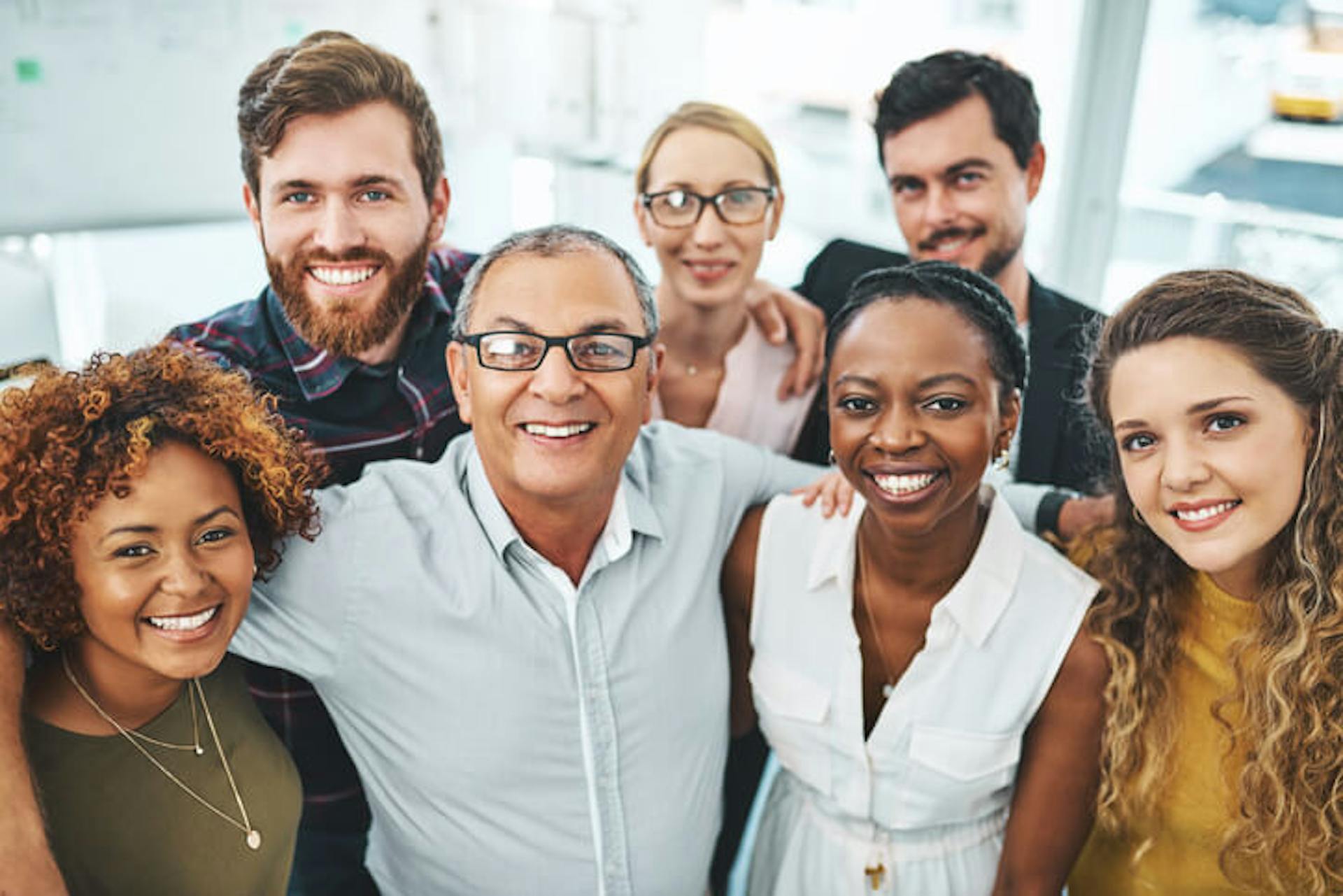 Office workers smiling in a huddle
