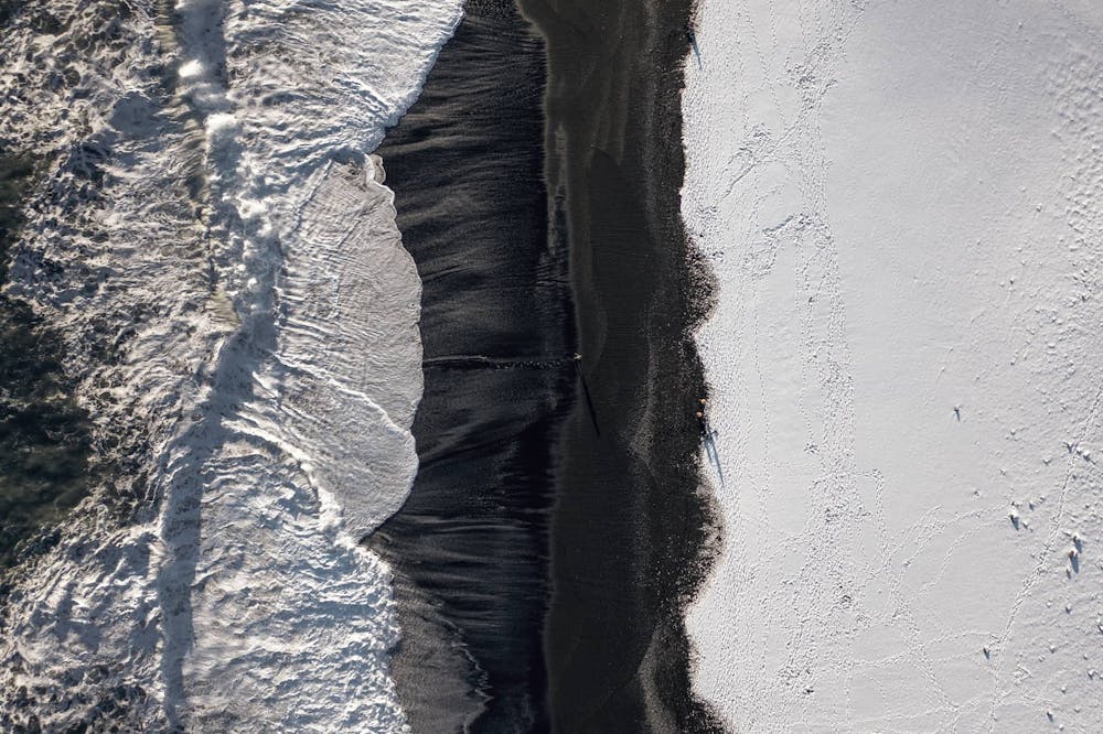 Iceland black sand beach and snow during the winter, bird's eye view