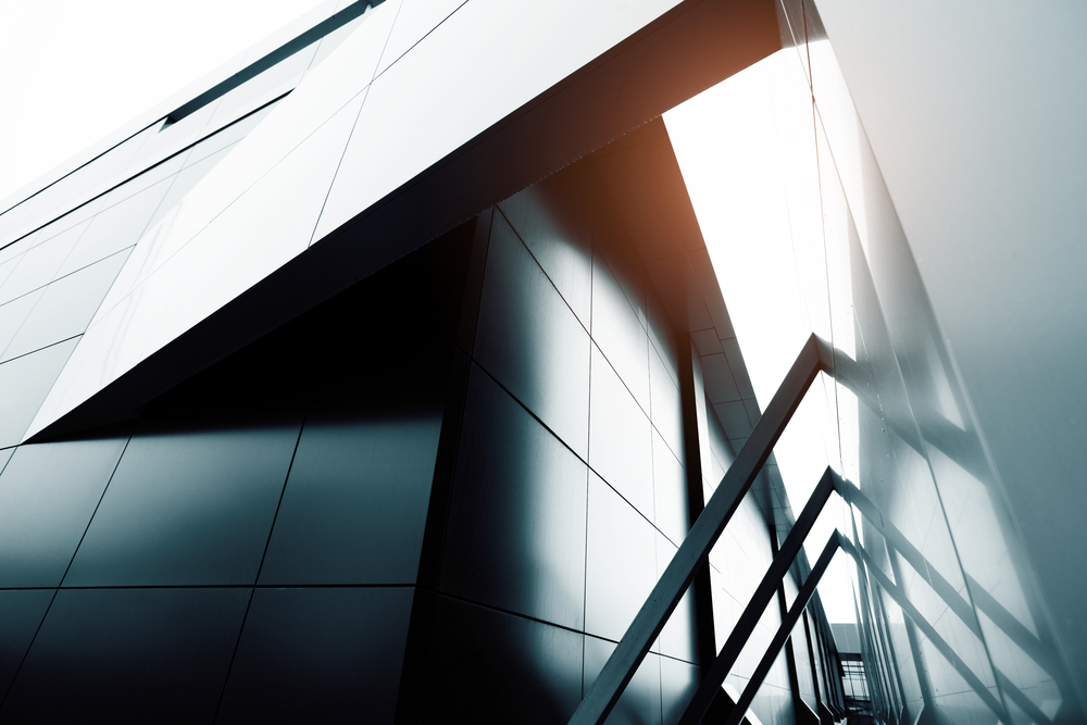 Abstrakt mynd af húsvegg, ljósbirta fellur á vegginn